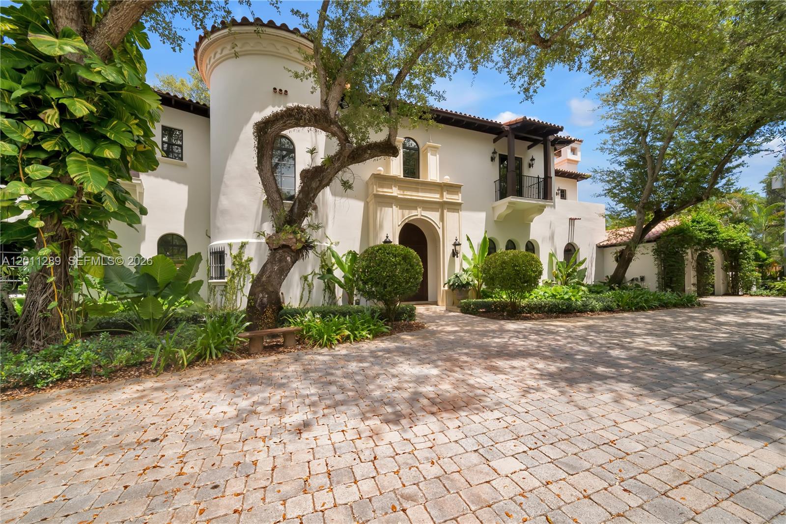 A rare estate in the exclusive Ponce Davis enclave, this classic Mediterranean villa by Giorgio Balli blends timeless architecture with a modern lifestyle, defined by quality craftsmanship, scale, and a level of privacy only properties of this magnitude can provide. Set behind gates on a lushly landscaped lot, the residence spans a total of  9,071 sqft, with 7 bedrooms, 6 full baths, and 2 half baths. Rich in character and architectural detail, the home features a grand double-height foyer with a signature spiral staircase, living areas filled with natural light, a gourmet kitchen, home theater, bar, and a library with fireplace. Upstairs, the primary suite offers a spacious bath and dual walk-in closets, alongside additional en-suite bedrooms with private balconies. 
The outdoor is an entertainer’s paradise: lagoon-style pool and spa, summer kitchen, coral rock patio, basketball court, and children’s playground, offering both space and privacy. A defining feature of the estate: the two-story guest house of approximately 1,100 SF thoughtfully designed to offer a versatile layout with dedicated gym or recreation space and a fully appointed one-bedroom apartment for private, independent living.
Tailored to a clientele who recognize true distinction