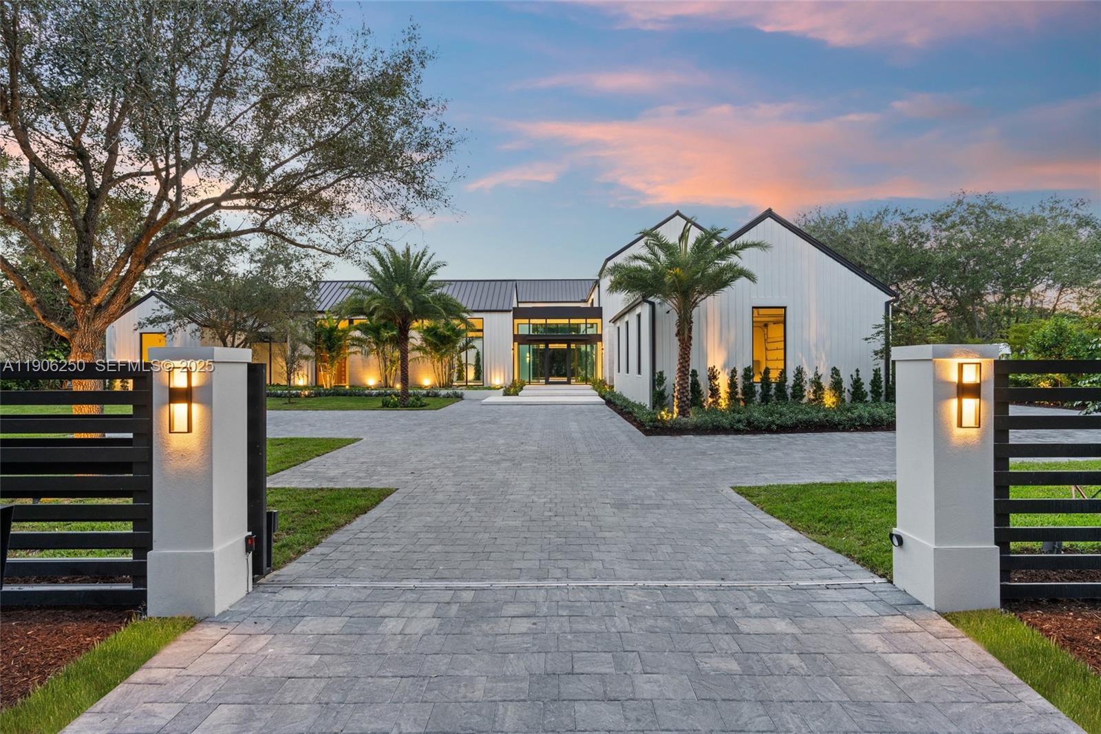 Crafted by Balli Group, this newly completed tropical modern estate epitomizes refined living in highly coveted Northeast Pinecrest. Thoughtfully designed by renowned architect Giorgio Balli, with interiors by Adi Balli, the 12,400 SF Residence rests on a quiet, gated 1+ acre site. It features 7 en-suite bedrooms, 7 full and 2 half baths, a 3-car garage with lift capacity for up to 6 vehicles, and dedicated golf cart or bicycle storage. Expansive glass walls open to a resort-style pool, summer kitchen, and lush gardens, creating seamless indoor–outdoor flow. Natural materials, soaring ceilings, and curated finishes define the interiors, complemented by a Savant smart-home system, elevator, wellness suite/gym, and media room.