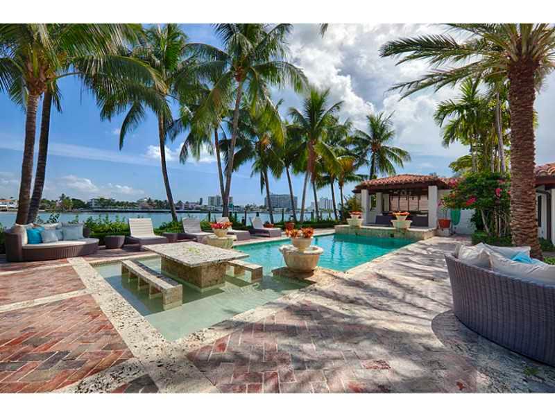 This phenomenal waterfront residence, located in gated La Gorce Island in Miami Beach, is a modern tropical oasis. This stunning 5BR/6+1BA home lined by exotic palm trees features marble floors and striking wood ceilings.  This contemporary home features  an open living space perfect for entertaining, master bedroom w/ 2 walk in closets & access to outdoor area with a stunning pool, gazebo, covered seating area, spa, dock and spectacular 104 ft waterfront w/ bay views.