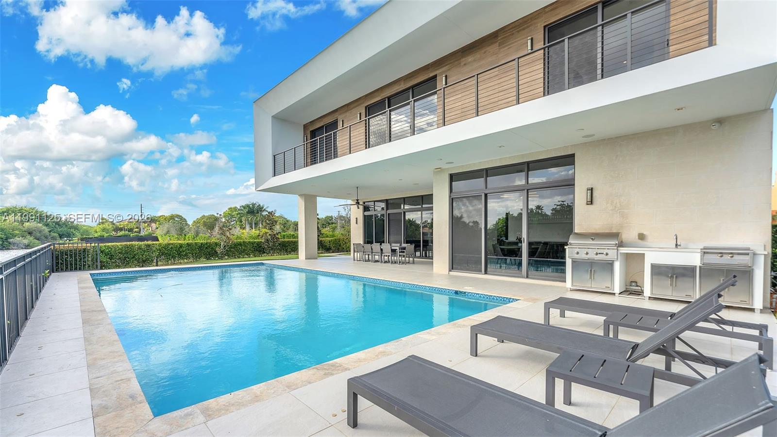 Welcome to Botaniko Weston Estates—modern luxury living in Weston. This Oppenheim Architecture O1 model sits on a prime corner lot with over 200 ft of lakefront, offering breathtaking sunrise and sunset views. Floor-to-ceiling windows fill the home with natural light, highlighting the spacious open-concept great room with a fireplace.

The chef’s kitchen features Wolf appliances, a Sub-Zero refrigerator, and a Bosch espresso machine. This smart home includes integrated speakers, electronic blinds, a security system, cameras, and keyless entry.

Enjoy 5 bedrooms, each with its own full bath, plus a media room/office or maid’s quarters, and a laundry room with sink. The 4-car customized garage and large paver driveway provide parking for 6-9 vehicles.

Step outside to a resort-style backyard with an oversized 20x40 pool, outdoor kitchen, and expansive patio overlooking the lake. Full-house generator included. Located in a gated community with 24-hour security.

Designed for comfort, style, and unforgettable living.
