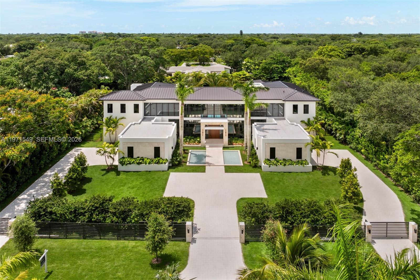 This brand-new transitional estate in Pinecrest embodies refined sophistication across 11,375 SF of impeccably designed living space. Featuring 8 luxurious bedrooms, 9 full baths and 1 elegant powder room, the home offers two serene primary suites, a private office and a custom theater. A detached guest house with kitchenette provides stylish accommodations. The gourmet kitchen showcases SubZero, Wolf and Al Fresco appliances with bespoke wood cabinetry. Walls of glass illuminate grand living areas and open to covered terraces, a heated pool and summer kitchen. Smart home automation, full generator and elevator ready design complete this exceptional residence.