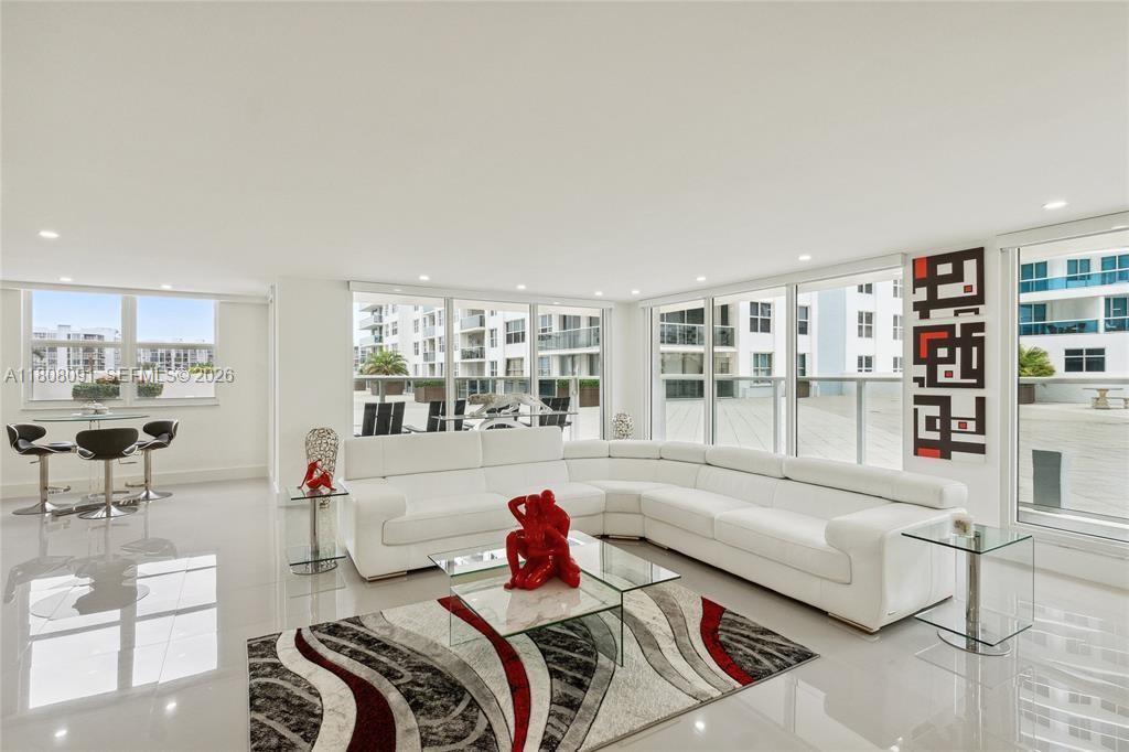 The BEST VALUE ON HOLLYWOOD BEACH. Rare walk-out lanai residence at Aquarius. This fully remodelled Beach-Villa 2-bed, 2-bath corner unit offers 1,768 sq ft of effortless indoor-outdoor living with direct access to the sunset pool deck and gym, no elevators, just step outside barefoot and enjoy the resort lifestyle. Designed for a lock-and-leave second home, the open-concept layout flows seamlessly from the living area to a semi-private lanai, perfect for relaxing or entertaining. Northwest exposure fills the home with afternoon sun and glowing sunsets. Features include a custom kitchen, white porcelain floors throughout, floor-to-ceiling windows with motorized zebra blinds, and a spacious primary suite with two walk-in closets and a spa-style bath featuring a glass shower and freestanding tub. Offered fully furnished with modern furniture. Assessments paid in full. Garage parking included. Aquarius amenities include two pools, an oceanfront BBQ area, an on-site restaurant, a fitness center, valet, and 24/7 security. Vacant and easy to show, this walk-out layout is a rare opportunity.