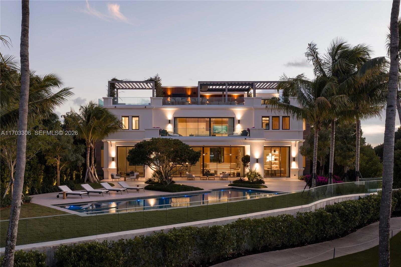 The first of just 12 residences to be built, Villa 6 at 1006 Links Drive is now complete and move-in ready—offering a rare opportunity to own the first fully turnkey home on Fisher Island. Set on 0.43 acres+/- and directly bordering the renowned Fisher Island golf course, this exceptional estate delivers elevated living within one of the nation’s most prestigious zip codes. A statement in contemporary luxury, the residence spans 12,470 SF+/- of interior living space and 4,510 SF+/- of exterior living space. With 7 bedrooms, 7 full bathrooms, and 2 half bathrooms, the home seamlessly blends refined design, expansive scale, and exclusivity. A gracious foyer and sweeping staircase set an impressive tone upon entry. Designed for both grand entertaining and everyday living, the first level offers effortless flow between living spaces and expansive terraces, pergolas, and outdoor lounges overlooking the pool, golf course, and water. The primary suite is a private retreat featuring a sitting area, workspace, oversized walk-in closet, and spa-like marble bathroom with dual vanities, soaking tub, and oversized walk-in shower—opening to a 572 ft terrace with pool, golf course, and water views. The third level is dedicated to wellness, complete with a private gym, massage area, steam room, sauna, and full bathroom. Above it all, the rooftop features a built-in kitchen, pergola-covered dining area, bar with TV, and sun deck lounge areas—creating the ultimate private resort experience.