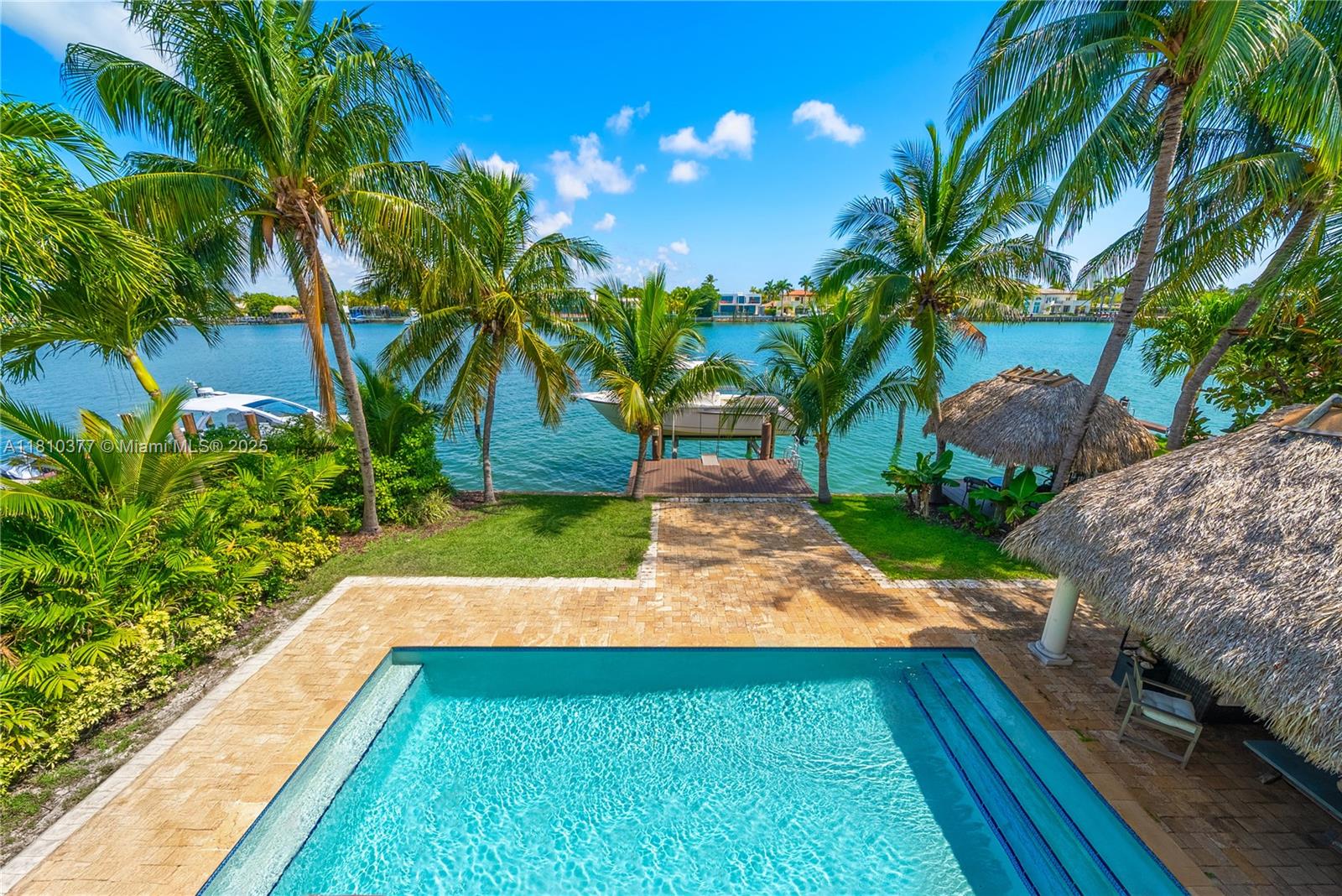 Mediterranean charm meets modern bay front living. Stunning 2-story waterfront home, rebuilt in 2010 and nestled in the exclusive, guard-gated island of Normandy Shores in Miami Beach. The grand entry foyer opens to 4,500 SF of refined living space, on a 11,000 SF lot with 65 FT of serene water frontage & unobstructed views of Biscayne Bay. The home features soaring ceilings, state-of-the-art chef kitchen, marble & Brazilian wood floors, and onyx bathrooms. The spacious, sun-filled primary suite, on the second floor, offers a private veranda and panoramic views. Step outside to your tropical resort-style pool, large dock w/ boat lift, and two tiki huts for extra island vibes. Enjoy community’s amenities: 18-hole golf, driving range, clubhouse, tennis, basketball, and children’s playground.