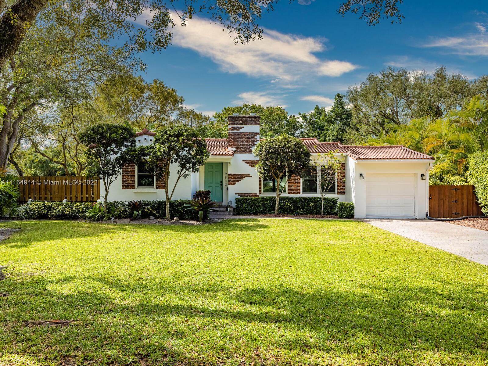 Welcome to The Corner Redbrick Charmer! Delight in this updated, enchanted home with expansive lush rear gardens on a great Miami Shores corner lot. Open living with signature fireplace flows to separate dining and updated chef’s kitchen plus a fabulous bespoke eat-in area and cool, curved niched shelves, perfect for favorite cookbooks and epicurean delights! Dreamy sleep in three bedrooms, plus new designer bathroom. Escape to the large screen porch overlooking spacious rear gardens with grand entertainment deck- get ready to fire up the grill, mix some cocktails and savor the tranquility with friends and family! Your personal oasis also has a one-car garage, impact windows-doors and hardwood floors, all in a non-flood zone just three blocks to downtown Miami Shores shops and restaurants.
