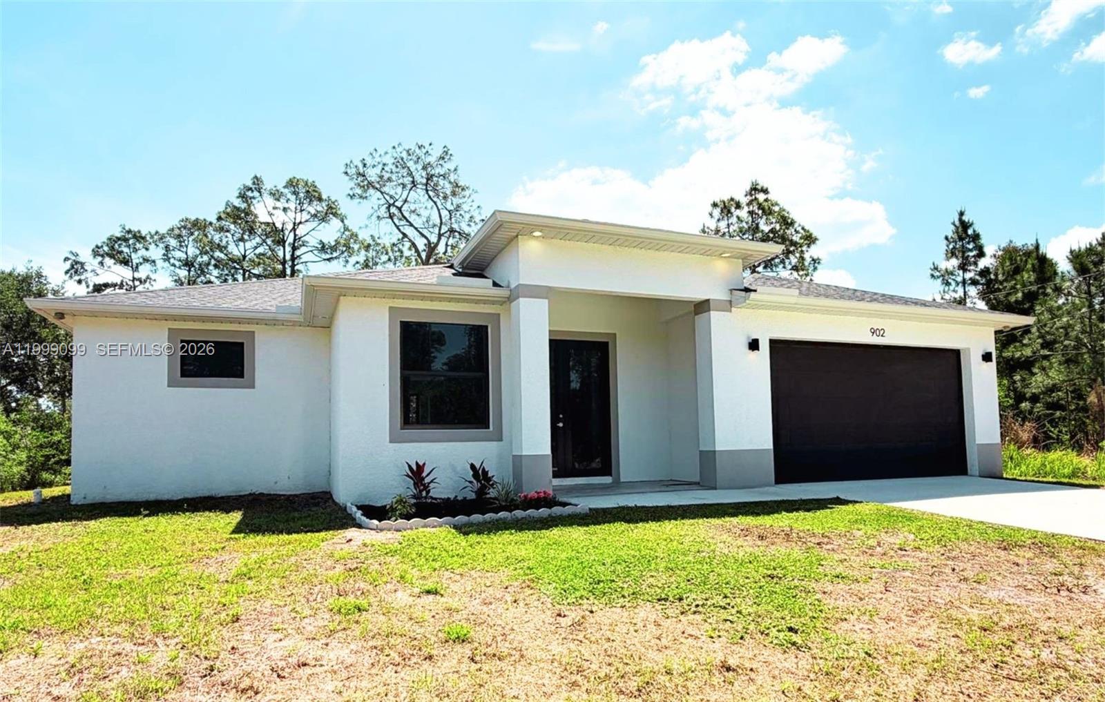 Excellent location! If you are looking for a brand new home in a prime area, this is the one. Located in the heart of Lehigh Acres, you will be just minutes from Veterans Park, schools, the recreation center, and the shopping and dining district on Lee Blvd. Huge half acre lot (0.50 acres), which offers a private retreat with space for a pool or additional parking, and no HOA. This new home features 3 bedrooms + den/office + 2.5 bathrooms. Upon entering, you are welcomed by an office space and a half bath that lead into a spacious living room with impressive 10 foot ceilings. At the back, there is a chef’s kitchen finished with premium granite countertops and stainless steel appliances. The primary bedroom is a true sanctuary, with two walk in closets and a spa like bathroom with a freestanding tub. Bedrooms 2 and 3 share a bathroom and a hallway. Built for your peace of mind with impact windows and doors, this property is the perfect combination of space, modern design, and future equity potential.