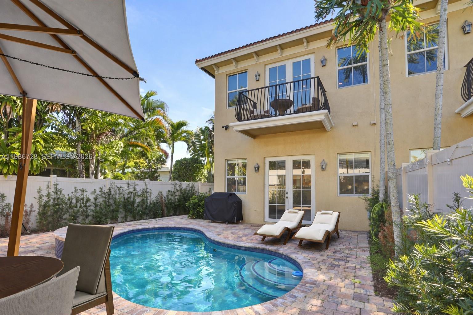 REMARKABLE VALUE - Seller is offering 6 Months of HOA Fees! HOA includes homeowners insurance! Turnkey and beautifully upgraded, this standout Villa Valentina corner-unit townhouse offers the ultimate Fort Lauderdale lifestyle. Enjoy your own private resurfaced pool with expanded pavers, plus convenient side access to the rear garden—ideal for entertaining and outdoor living. The home also features a private two-car garage with elevated storage and an EV charger. Inside, the 3-bedroom, 2.5-bath layout showcases soaring ceilings, quartz countertops, 2023 KitchenAid appliances, LED lighting, a sleek modern electric fireplace, and high-end designer finishes throughout. The primary suite is a true retreat with dual walk-in closets and a spa-style bath complete with a freestanding tub and dual rainfall showers. Impact glass, smart home features, refreshed landscaping. Just minutes from the beach, Las Olas, and downtown hotspots.
