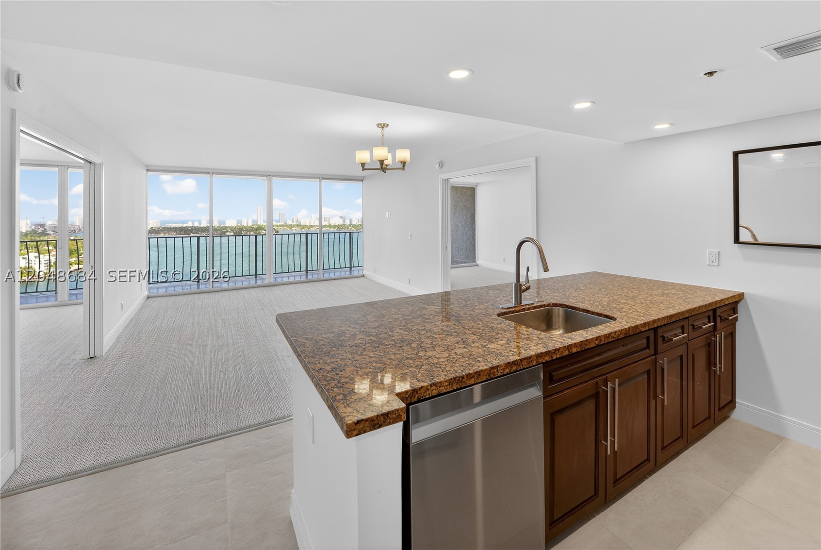 Beautifully maintained 2-bedroom, 2-bath waterfront residence in Grandview Palace’s most desirable line, offering sweeping east-facing views over the bay and Normandy Island. This split-plan layout is enhanced by high-end carpeting throughout the bedrooms and living areas, creating a soft, elevated feel that sets the tone from the moment you enter. Luxury pocket doors add flexibility and a more open-concept flow, while the full-width balcony spans the entire residence and is accessible from both bedrooms and the living room, allowing every room to connect to the view. The open kitchen features generous counter seating and flows comfortably into the main living space, while the in-unit washer and dryer add everyday convenience. Located in a full-service waterfront building with 24-hour security, pool, fitness amenities, marina, ground-floor shops and restaurants, plus two parking spaces.