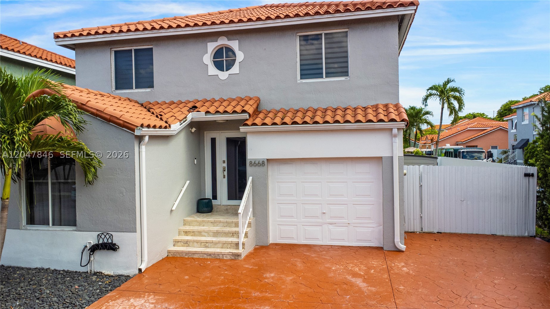 Beautifully updated 3BR/3BA two-story corner home featuring a modern open layout, soaring ceilings, tile floors, recessed lighting, and a stunning glass staircase. Bright, move-in ready impact windows and doors and stainless still appliances.  The garage has been converted into a spacious family room overlooking the kitchen and can easily be converted back into a garage if needed. With a barrel tile roof, stamped concrete driveway for up to 3 vehicles, and fenced yard with spacious side access throughout an electric door. Conveniently located near shopping, dining, schools, parks, and major highways. Tonal is not included in sale. A perfect blend of style, comfort, and convenience! Low HOA, a must see!