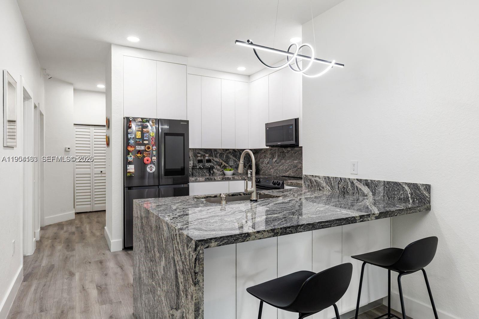 Completely Remodeled 3/2 Condo in Gated Silver Falls! This stunning 3-bedroom, 2-bathroom condo features a one-car garage, newer wood flooring, and a modern kitchen with wood cabinets and granite countertops. Bathrooms are upgraded, and the primary suite includes a large walk-in closet. Enjoy beautiful garden views from every window and the peace of mind of a hurricane-impact window. Located within walking distance to the clubhouse with premium amenities: Pickleball, basketball courts, children’s play area, and swimming pool. Maintenance covers: building exterior, cable, landscaping, roof repair, water, and sewer. Perfect for those seeking a move-in ready home in a highly desirable gated community!