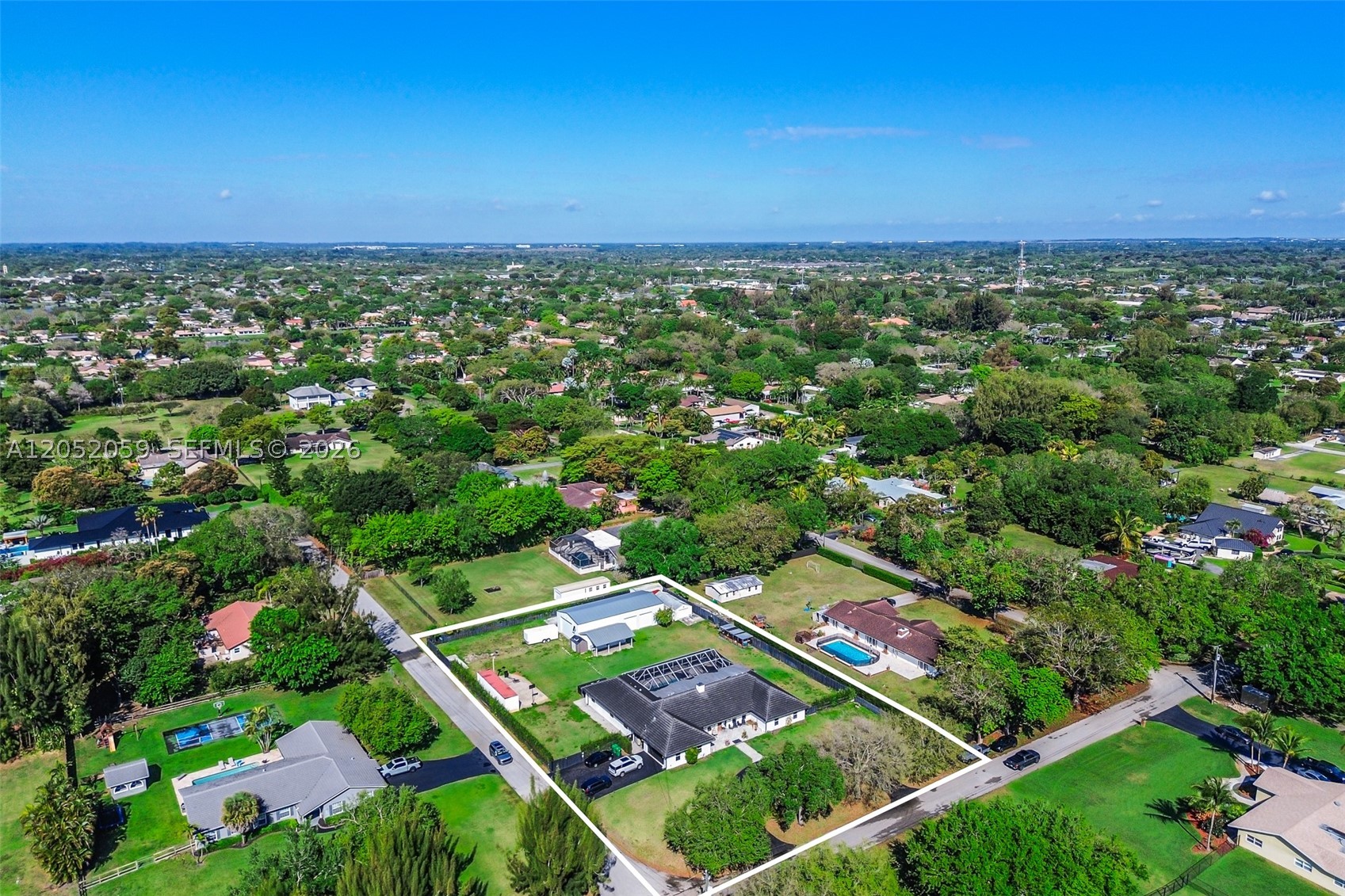 Welcome to a rare opportunity in the heart of Davie! Situated on a prime corner lot over an acre, this beautifully maintained property offers the perfect blend of space, functionality, and lifestyle. The main home features a thoughtfully designed layout with a private office, gym, and game room ideal for both everyday living and entertaining. Along with 5 bedrooms! The recently remodeled kitchen showcases modern finishes and flows seamlessly into the living areas, while impact windows and doors provide peace of mind throughout. A 5-year-old roof adds to the home's overall value and condition. Step outside to your private backyard oasis, complete with lush landscaping, a screened-in pool, covered patio, and a fully equipped outdoor kitchen perfect for entertaining. The expansive lot also features a large detached shop, ideal for car enthusiasts, business use, storage, or even accommodating animals. Additional highlights include a circular driveway, dedicated slabs for RV and boat parking, and a 200’ well water system.