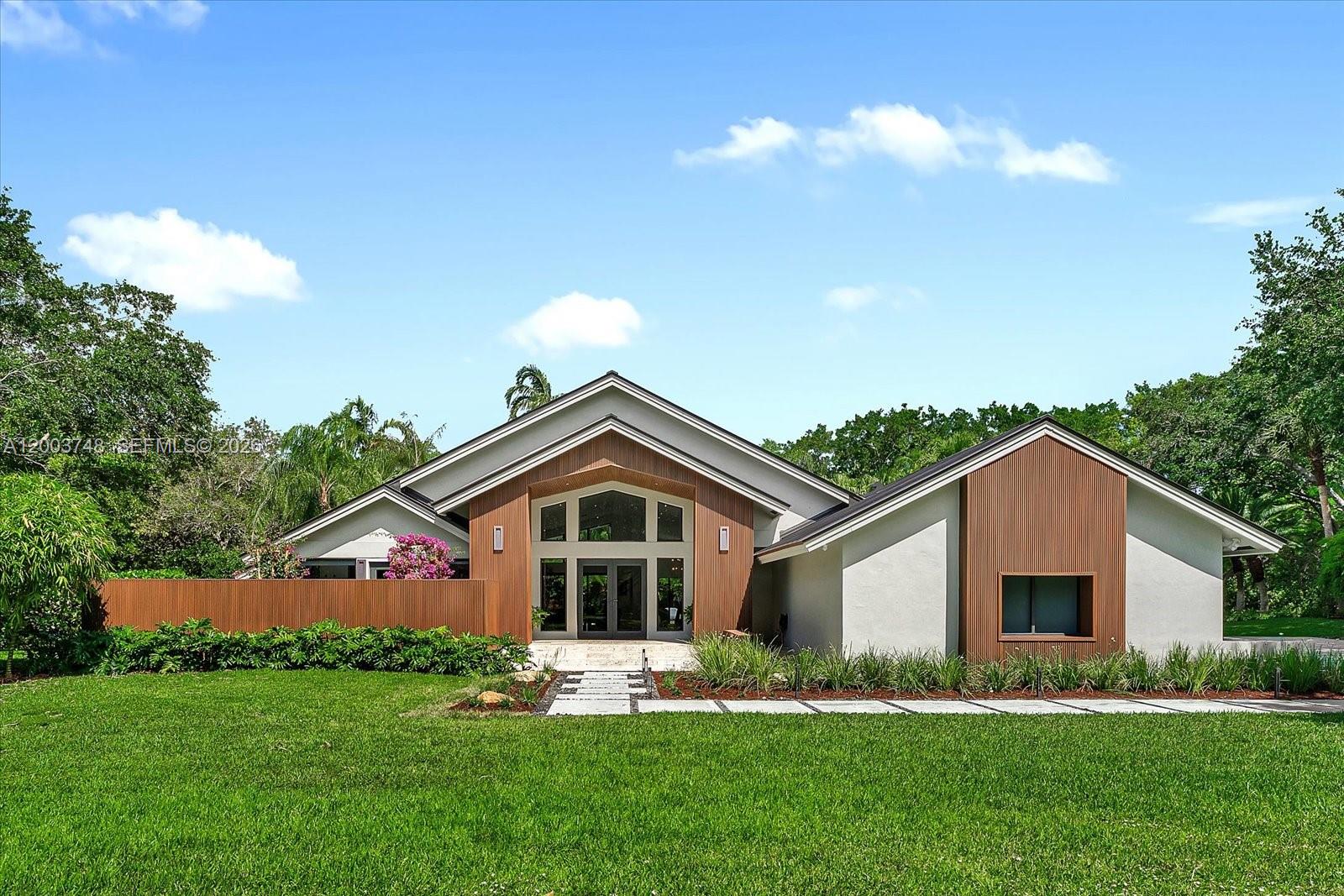 Welcome to a private, design-forward estate set on approximately 1.33 acres within Weston’s most exclusive gated community—where modern architecture, Italian craftsmanship, and resort-style outdoor living come together seamlessly.
From the moment you arrive, the home makes a striking impression with its new metal roof, expansive setting, and meticulously curated landscape of sculptural plantings and refined hardscape. Inside, a clean architectural language unfolds with Italian porcelain flooring, trimless lighting, and custom Italian interior doors with concealed hinges, creating a seamless, gallery-like aesthetic.
Light-filled living spaces flow effortlessly, anchored by a stunning Poliform kitchen equipped with a professional Sub-Zero and Wolf suite, integrated refrigeration, and a 76-bottle wine fridge-designed for both everyday living and elevated entertaining.
Private quarters continue the design narrative with designer wall coverings throughout and a custom Poliform walk-in closet in the primary suite, offering a boutique-level experience. 
Glass-lined interiors open to a resort-style outdoor setting featuring dual lounge areas, a tranquil pool, sun deck, sculptural wood lounge, pergola dining area, and intimate garden spaces—surrounded by lush, designer landscaping that enhances both privacy and ambiance.
Located in Windmill Ranch Estates, this residence offers a rare combination of privacy, scale, and world-class design. A fully realized luxury living experience.