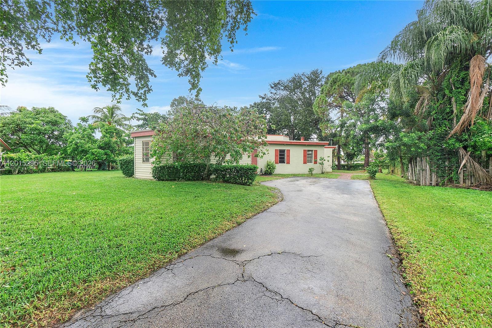One of the largest lots in the area with so much potential! Welcome to an exclusive circular haven in Lauderhill! Step through the screened entryway, this home has so much potential!! With a lush backyard and captivating lakefront views. This home features a unique layout, with the kitchen being located in the heart of the home and split floorplan with living areas and bedroom areas on opposite sides of the home. This lovely kitchen lets in sunlight through multiple skylights. Beautiful wood ceilings exude warmth and sophistication, while the original fireplace adds a touch of nostalgia. Embrace the freedom of no HOA restrictions.