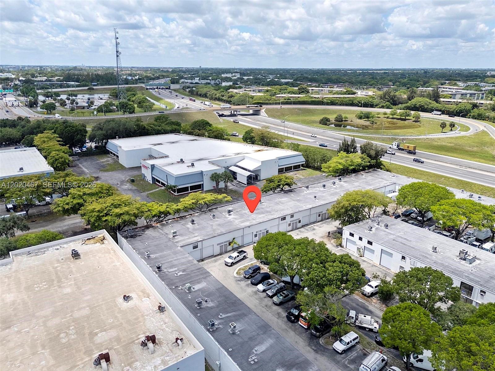This versatile I-1 zoned industrial commercial space with a 20' ceiling height is an exceptional opportunity for e-commerce, warehousing, light manufacturing, assembly, fabrication, packaging, or live/work business operations. Strategically located just minutes from major shipping hubs including FedEx, UPS, and USPS, with immediate access to the Turnpike and major highways, this fully air-conditioned property is designed for efficiency, security, and functionality.

Seller upgrades include industrial steel warehouse racking and shelving systems with multi-level mezzanine storage platforms, built-in storage units, warehouse lift equipment, second-floor lift access, climate control with Google Nest thermostat, tankless water heater, remodeled kitchen, enhanced electrical lighting, and extensive security features including bars on windows and metal front entry door.

A dedicated production/workshop room is fully equipped for light manufacturing or operational support, offering industrial workstations, expansive counter space, shelving, overhead task lighting, and ventilation.

Additionally, the seller-installed enclosed rear flex space adds significant value with a private finished room featuring separate wall and door enclosure, kitchenette and full bathroom.

HOA includes water, trash, and exterior insurance, making this a rare turnkey commercial solution for growing businesses seeking prime logistics convenience and adaptable operational space.