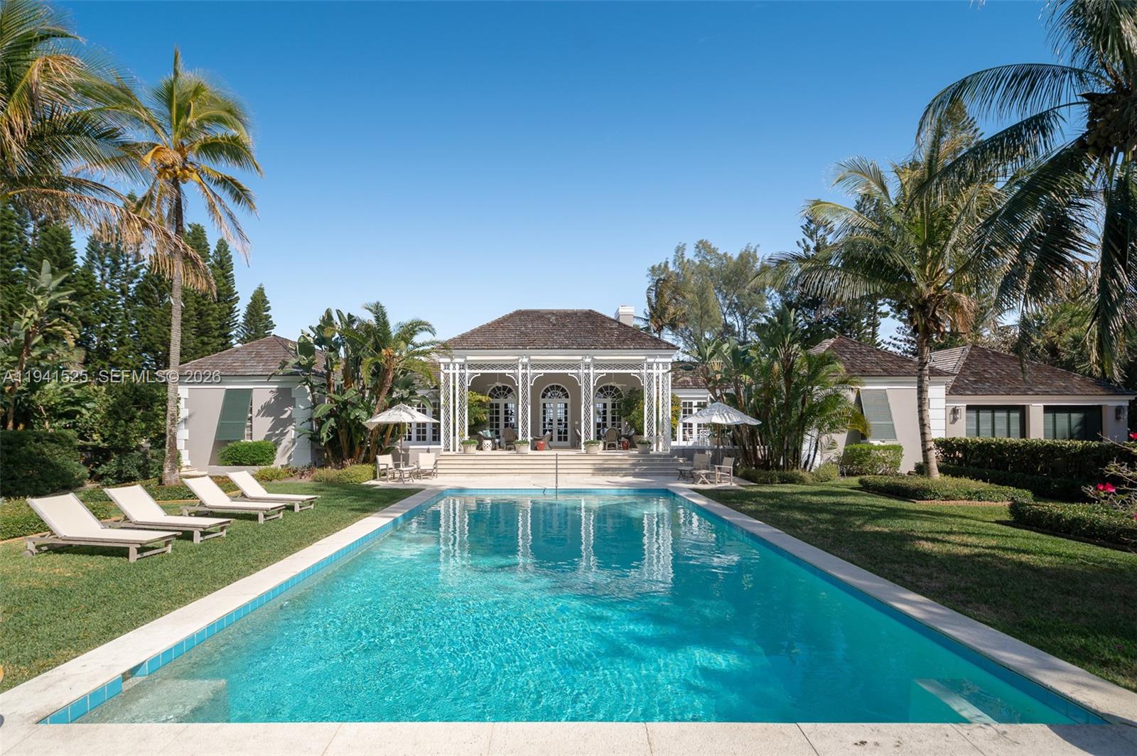 An exceptional opportunity to acquire an architecturally significant oceanfront property on Jupiter Island, with approximately 210 feet of oceanfront. The 4-bedroom, 5-bath main residence features balanced proportions, gracious scale, and ocean views from nearly every principal room, complemented by a separate oceanfront office that offers a private, light-filled workspace.
The grounds are thoughtfully composed of formal yet relaxed island gardens, a large swimming pool, and a covered veranda with classic fretwork, creating a timeless setting for indoor-outdoor living and elegant entertaining. A separate service drive provides discreet access to a two-car garage, a golf cart garage, and a one-bedroom guest suite, ensuring privacy for guests.
This oceanfront property is a must-see, presenting a rare opportunity to own a Jupiter Island residence with lasting appeal and thoughtful potential.