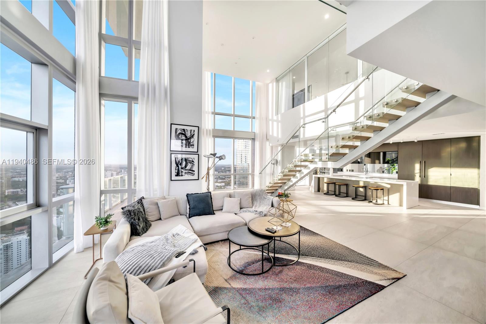 Experience the ultimate "Duplex in the Sky" in this dramatic, double-story furnished trophy residence at Paramount Miami Worldcenter. Boasting a private foyer and soaring two-story glass walls, Penthouse 4612 offers approximately 3,800 square feet of interior luxury and four outdoor terraces spanning an additional 417 square feet, featuring panoramic views of Biscayne Bay, the Miami skyline, and vibrant western sunsets. This sprawling layout provides the seamless flow of a single-family home paired with the thrill of high-rise living, highlighted by an oversized primary suite with a spa-inspired bathroom and a versatile "lock-out" studio complete with its own entrance, kitchenette, and full bath. Residents enjoy access to the world’s most extensive amenity package—including five resort-style pools, a soccer field, tennis courts, a state-of-the-art gym, and a full-service spa—all while being steps from the Kaseya Center, elite retail, Miami’s finest restaurants and major transit. Perfectly positioned in the heart of the city, you are minutes from Brickell, Wynwood, Miami Beach, and MIA Airport.