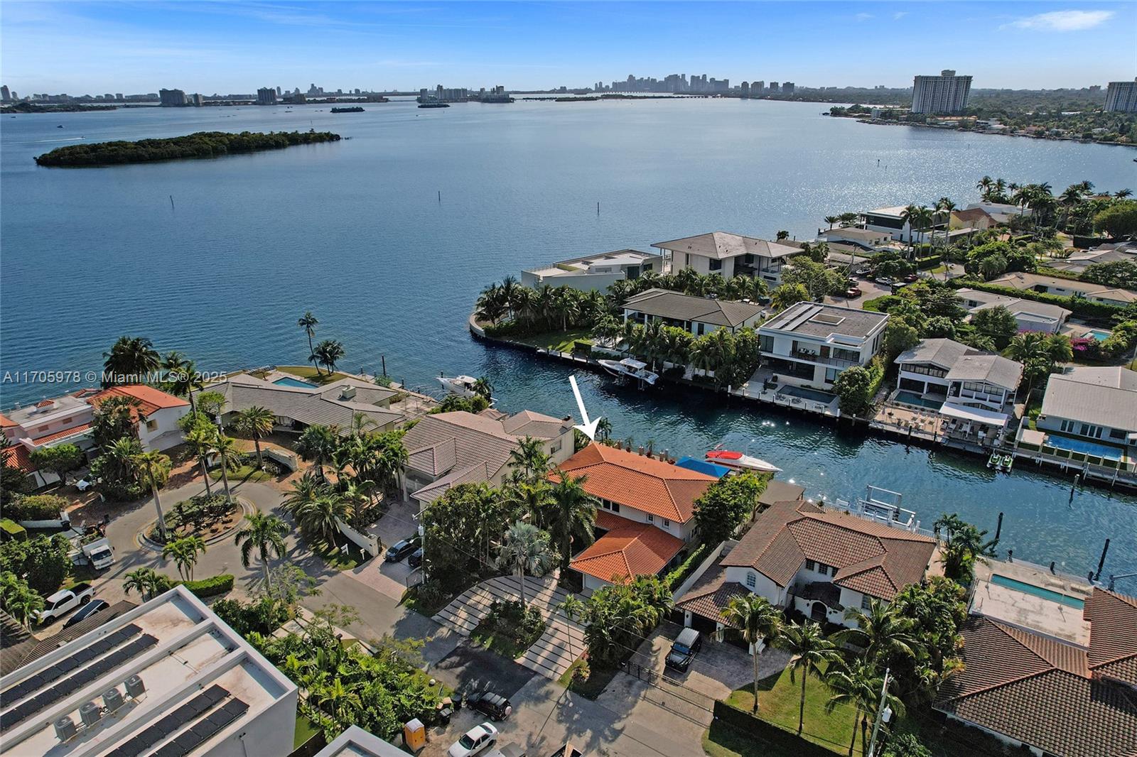 One of a kind with Bay views!!!! Located in the gated, police-protected community of Sans Souci Estates, this 2-story concrete home offers breathtaking open bay views and an extra-wide deep-water canal with ocean access just minutes away. Perfect for larger boats, it features a 20,000-lb boat lift and a sprawling outdoor entertaining area with a pool, lush landscaping, and up-lighting. Inside, enjoy 5BR/4BA, soaring ceilings, marble floors, and natural light throughout. The oversized master suite boasts one of the largest layouts in the area, a spa-like bath, and a huge private terrace overlooking the bay. The air-conditioned 2-car garage doubles as flexible space. This premium property shines day and night, offering luxury waterfront living at its finest.