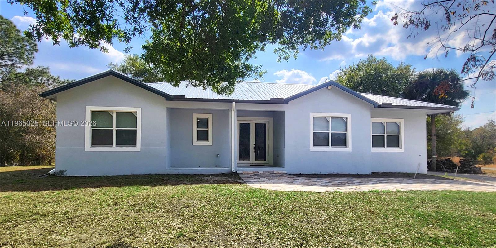 Discover this STUNNING 2024-built home in Montura Ranch Estate, Florida, featuring 2,142 sqft. OF LIVING SPACE. This concrete home blends modern design with luxurious finishes and a functional layout. The living area is EXCEPTIONAL SPACIOUS. Complemented by HIGH CELINGS that create an open, bright atmosphere. The home offers 3 BEDROOMS, 2 FULL BATHROOMS, and a FLORIDA ROOM that can also serve as a den or additional workspace. The MASTER BEDROOMS measures 13x25 ft, with a spacious ensuite including a shower, soaking tub, and double vanity. The kitchen boasts wood cabinets and QUATZ COUNTERTOPS, A BIG ISLAND along with high-end stainless steel appliances. Other highlights include a front porch, smoke detectors, a five-ton AC system, tile flooring, paved driveway, and an elegant gated entrance. All this sits on a private 1.25-acre lot, fully fenced and featuring FRUITS TREES as COCONUTS, PAPAYA, GUAVA, and PASSION FRUITS, creating your own tropical oasis. The property also features a spacious BACKYARD SHED that can be used for tool storage, a workshop, or additional workspace.With no HOA fees, this home offers comfort, privacy, and style in every corner.