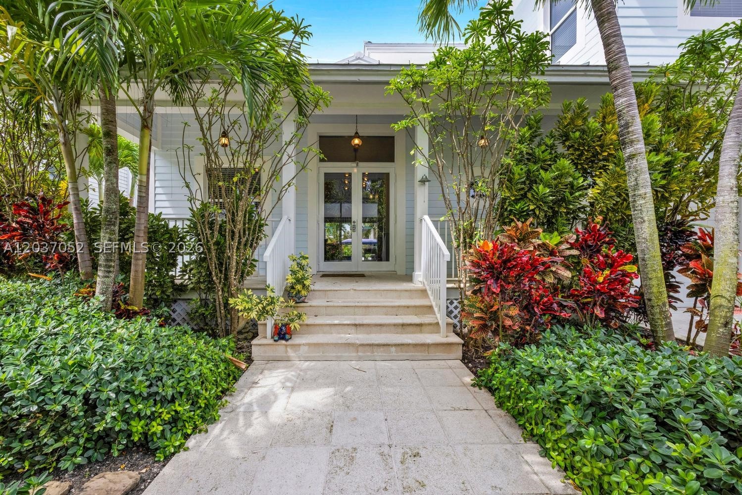 Experience the relaxed elegance of Key West living at this exceptional waterfront retreat on prestigious NE Little River Drive. Situated on an expansive 11,250-square-foot lot with approximately 75 feet of waterfront frontage, this fully furnished 5-bedroom, 4-bathroom residence offers over 4,200 square feet of beautifully designed living space and an unmatched resort-style lifestyle. The home's coastal architecture, expansive covered verandas, pastel island-inspired colors, and lush tropical landscaping create the feeling of a private Caribbean resort. Designed for seamless indoor-outdoor living, the residence features soaring ceilings, rich hardwood floors, abundant natural light, and spacious gathering areas throughout. The chef's kitchen is the heart of the home, featuring custom coastal cabinetry, quartz countertops, stainless steel appliances, double wall ovens, and generous entertaining space overlooking the pool and waterfront. Outside, discover your own tropical oasis complete with a resort-style pool, expansive sun deck, waterfront lounging areas, private dockage, summer kitchen with a covered dinning area and beautifully landscaped grounds.