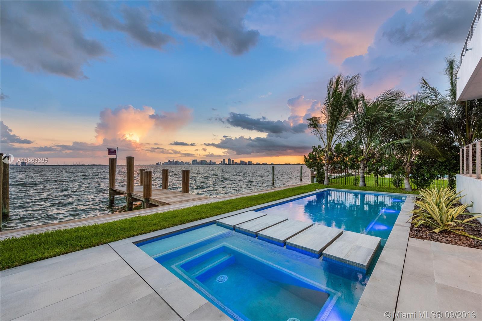 Stunning new modern bayfront home offering unobstructed views of the wide bay & the Miami skyline! Dramatic contemporary design with double-height floor-to-ceilings glass entrance & views of the water will welcome you into the open concept floor plan with wall-to-wall glass doors & 10-ft ceilings thru-out. Finishes Include: Mia Cucina kitchen, SubZero & Wolf appliances, floating stairway, Italian doors, terraces, walk-in closets, & more. Five beds up, including a bayfront master suite with a sitting area, huge terrace, walk-in closet, & luxe bath. The backyard features a heated pool with a spa, huge covered patio with summer kitchen, & new seawall & dock. The property is gated & equipped with a 2-car garage, & centrally located between Miami Beach & Miami. Built in 2019 by On One Group.