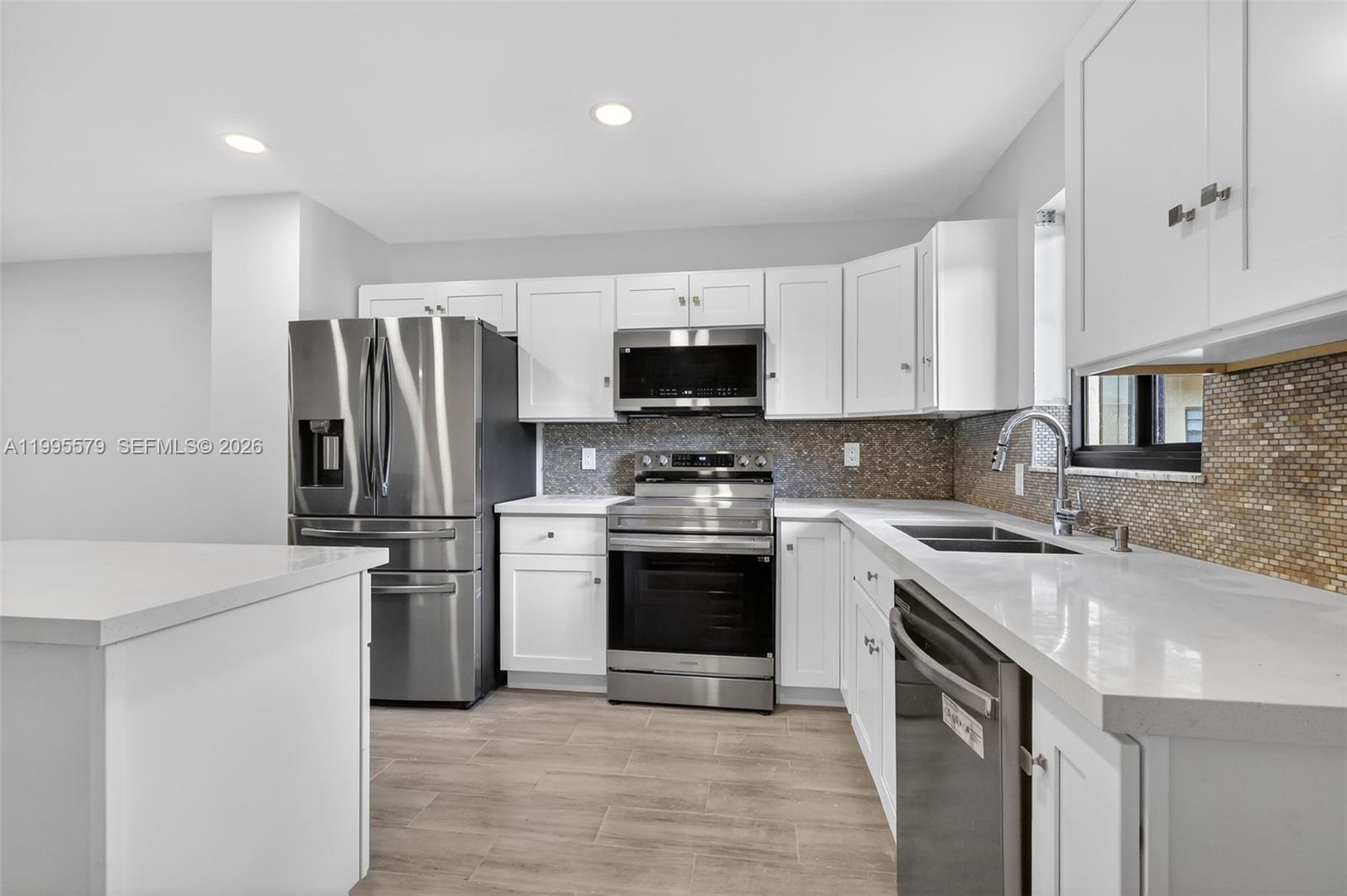 Beautifully remodeled 2 bedroom, 2 bath condo located in the gated community of Villas at Carriage Hills! This is an all ages building. This stunning first floor unit features a modern open concept great room floor plan with sleek tile flooring throughout. The updated kitchen boasts elegant white cabinetry, brand new stainless steel appliances, and a stylish island, perfect for entertaining. Two spacious bedrooms, 2 bathrooms, ideal for privacy, along with generous storage and a walk in closet. Impact Glass. Enjoy relaxing in the screened in patio, adding extra living space and comfort. Residents enjoy a scenic walking trail around the lake, BBQ areas, fitness center, sauna, game room, basketball and tennis courts, and many other amenities. Prime location in the heart of Hollywood, just across the street from shopping, restaurants, and banks, and only minutes from Nova Southeastern University, the Hard Rock Guitar Hotel & Casino, major highways, and Fort Lauderdale International Airport.