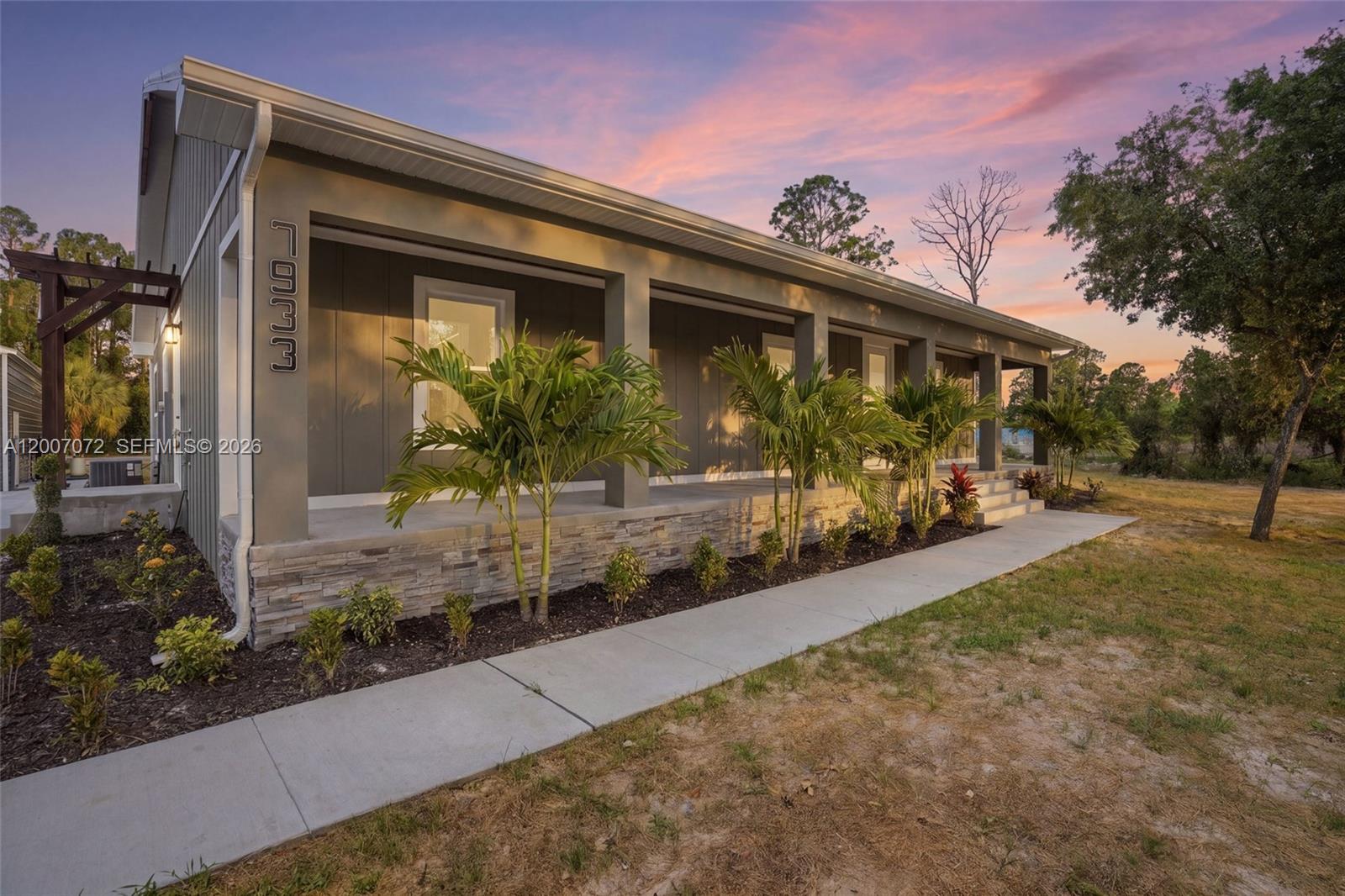 Welcome to your private slice of Southwest Florida living—where modern craftsmanship meets peaceful, wide-open space. This brand-new custom-built home sits on 1.25 acres, offering privacy, functionality, and elevated design. From the gated entry and long driveway, you’ll appreciate the thoughtful layout and curb appeal, along with a spacious front porch perfect for relaxing. Inside, the home features high-end finishes, exposed wood beams, and a warm fireplace anchoring the open-concept living space. The kitchen includes a farmhouse sink, granite countertops, and quality finishes for easy everyday living and entertaining. Hurricane impact windows and doors add durability, while LVP and tile flooring provide style and low maintenance. Step outside to an outdoor kitchen with wood plank ceilings and a gas grill, ideal for Florida living. A 500-gallon propane tank services the stove, hot water heater, and grill for added convenience. The detached 4-car garage offers ample space for vehicles, storage, or a workshop. Nearing completion in 2–3 weeks, this is a rare opportunity for brand-new construction on acreage without the wait.