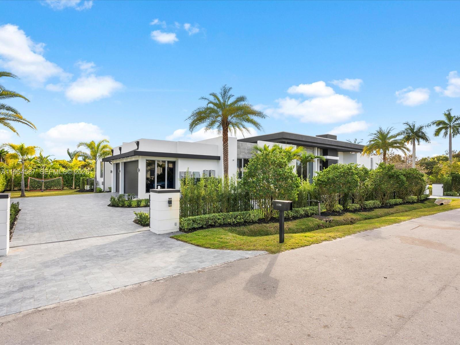 For the buyer who wants it all; privacy, design, and immediate livability! 
A rare modern estate in Plantation Acres, set within a private enclave of just five custom homes. Designed by acclaimed architect Randall Stofft and enhanced with extensive bespoke upgrades, this residence delivers a refined, truly turnkey living experience.
Soaring ceilings, walls of glass, and curated materials define the open living spaces, creating seamless flow between living, dining, and entertaining areas. A statement kitchen, architectural wine wall, and designer bar anchor the home. The primary suite offers a serene retreat with spa-level finishes and generous walk-in closets, while four additional bedrooms are thoughtfully positioned on the opposite wing for privacy. Expansive sliding glass doors fully open to the outdoors, where resort-style living unfolds with a pool and oversized spa, covered terraces, a fireplace, and lush landscaping designed for privacy and relaxation.
Ideally positioned near top-rated schools, including American Heritage, premier grocery stores, luxury shopping, dining, and major highways, balancing everyday convenience with long-term value.
This is a rare opportunity to step directly into a finished, elevated lifestyle.