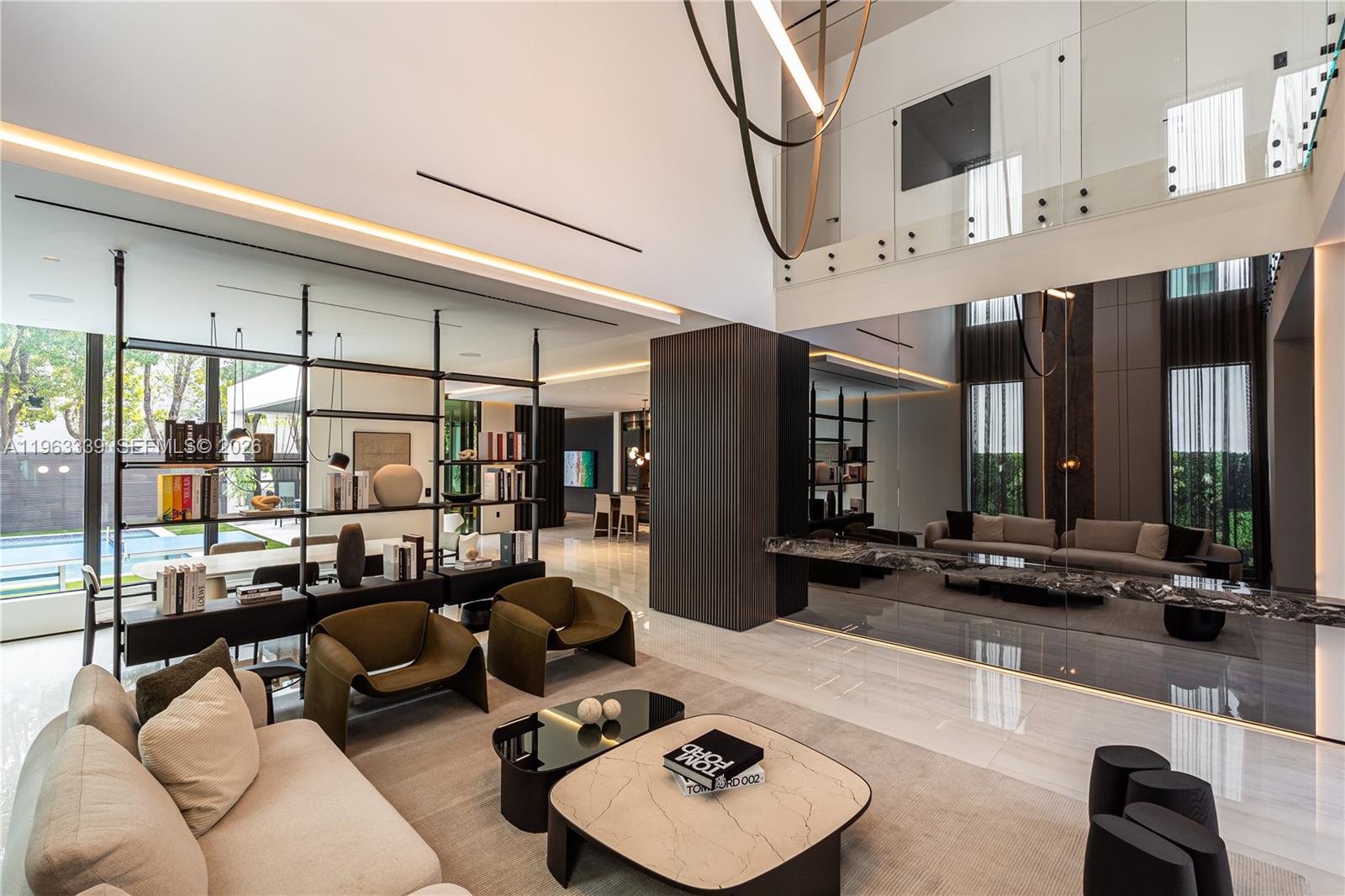 This minimalist contemporary luxury home is a masterfully designed residence curated with uncompromising attention to detail, delivering a true high-end living experience. The home features a full WAC architectural track lighting system throughout, complemented by recessed linear LEDs, ambient cove lighting, and a dramatic Flos AIM statement fixture accentuating the double-height living space. A fully integrated Smart Home system with Lutron Shades and Control4 allows seamless control of lighting, climate, and ambiance, while a whole-home speaker system provides integrated audio throughout. Interiors showcasing sculptural contemporary pieces and anchored by a striking Lexington central shelving unit by Poliform, conceived as a gallery-style architectural focal point. The residence is finished with large-format marble-design flooring and flawless Level 5 smooth wall finishes, reflecting a museum-quality execution. Custom sheer and blackout drapery systems provide refined light control and privacy throughout. The Italian Poliform kitchen is a true showpiece, featuring sleek European cabinetry, premium integrated appliances, and an oversized full-slab waterfall island—ideal for both entertaining and everyday luxury living. The primary suite offers a boutique-style custom walk-in closet with illuminated shelving. A finished garage adds versatility as a lounge, studio, or private gym. Every element of this home reflects a refined, luxury standard.