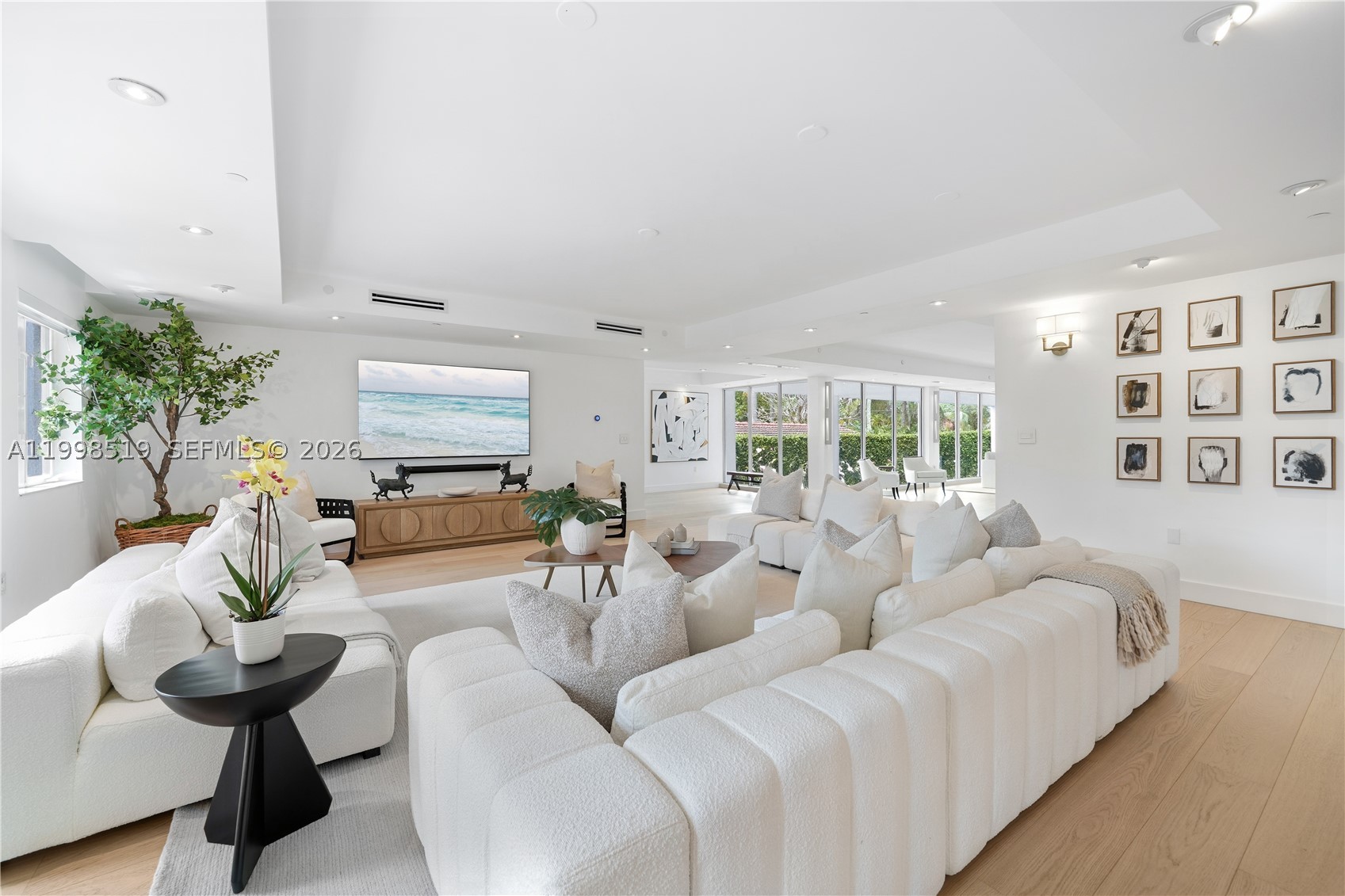 An architectural statement on Palm Island's exclusive guard-gated enclave, this fully reimagined contemporary residence delivers a rare combination of scale, privacy, and elevated resort-style living. Spanning more than 6,600 square feet across three levels, each accessible by private elevator, this home was meticulously redesigned to maximize light, volume, and seamless indoor-outdoor flow. Walls of floor-to-ceiling glass frame every principal living space, flooding the interiors with natural light while creating an effortless connection to lush tropical surroundings. Wide-plank hardwood floors and refined Italian finishes establish a sophisticated yet relaxed atmosphere throughout. Designed for both intimate living and grand-scale entertaining, the expansive living room, sunroom, dining area, and chef's kitchen unfold as one stunning open-concept environment. Dual primary suites offer a private sanctuary experience, complete with custom Italkraft closets and spa-like baths finished with imported Italian materials. The crown jewel is a 2,700+ SF rooftop sky terrace, among the largest private rooftop retreats on Palm Island, delivering panoramic water views, glowing sunsets, and the iconic Miami skyline as an unforgettable backdrop. Moments from South Beach, world-class dining, and luxury shopping. A rare turnkey opportunity in one of South Florida's most coveted neighborhoods.
