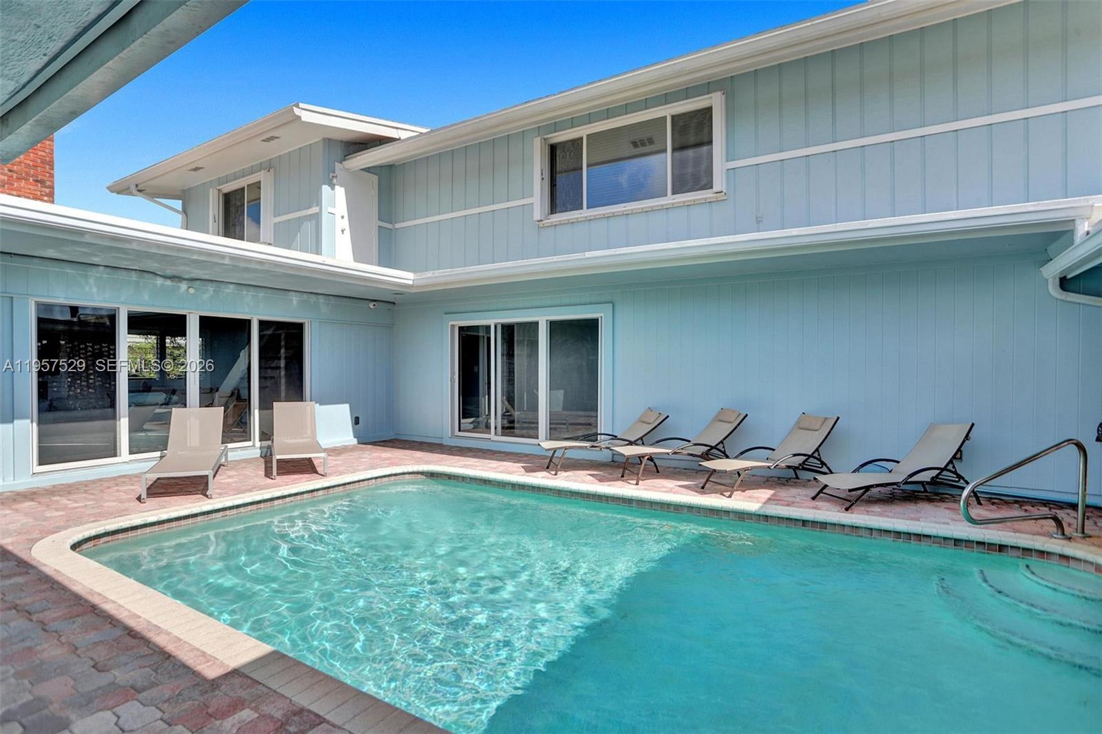 Stunning Beach–style residence blending timeless charm with modern upgrades. This beautifully maintained 6-bedroom, 3-bathroom two-story home offers an ideal layout with 2 bedrooms and 2 full bathrooms on the main level. Thoughtfully designed interiors feature first-floor entry, a spacious kitchen with island and snack bar, fireplace, walk-in closets, and elegant finishes throughout. High-impact windows, plantation shutters, and custom blinds enhance both style and functionality.

Step outside to a private tropical oasis with a beautiful  pool, expansive patio, open porch, and fully fenced backyard—perfect for entertaining or relaxing in complete privacy. Additional highlights include circular driveway, attached garage, exterior lighting, and serene garden and pool views. A rare opportunity to own a classic Florida home with exceptional indoor-outdoor living - Above Ground Jacuzzi Firepit - Furniture Available for purchase all you need is your toothbrush