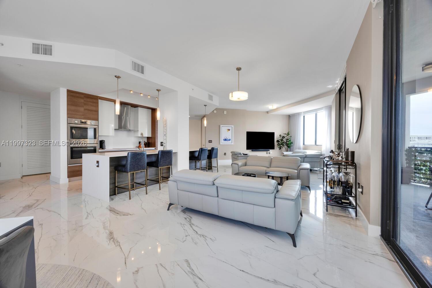 The largest residence in Merrick Manor, this impressive LPH corner unit offers 4 bedrooms and 4 baths with a thoughtfully designed split floor plan. The private primary suite features a spa style bath and custom closets, while a true junior suite provides comfort for guests, complemented by two additional bedrooms ideal for family or office use. The chef's kitchen showcases sleek cabinetry and an expansive island flowing into open living and dining areas. A spacious terrace captures stunning sunset views and natural light. Features include porcelain floors, impact glass, keyless entry, and 2 garage spaces. Enjoy concierge, valet, pool, fitness center, and lounge, all moments from Merrick Park, UM, and Miracle Mile.
