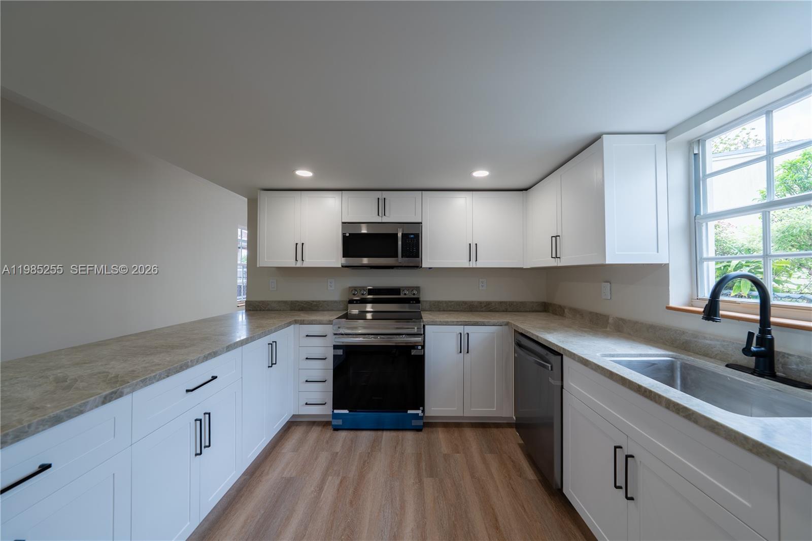 Completely reimagined from top to bottom, this fully renovated residence offers a seamless blend of modern design and thoughtful craftsmanship while maintaining its original layout for optimal functionality. Every detail has been carefully curated. The exterior has been entirely transformed with new stucco and sealing, delivering both durability and striking curb appeal. Step outside to enjoy brand new balconies crafted with premium thermal ash wood, adding a warm, sophisticated touch to the home’s outdoor spaces. Inside, the kitchen stands as a true centerpiece, featuring elegant shaker-style, lacquer-finished millwork paired with stunning Taj Mahal countertops perfectly balancing style and practicality. Throughout the home, you’ll find new laminate flooring, solid oak window sills, and beautifully finished solid oak stair treads that elevate the overall aesthetic. Every room is equipped with brand new custom closets and sleek single-panel doors, while the bathrooms have been completely remodeled with new vanities, fixtures, and toilets offering a spa-like, move-in-ready experience. To complete the renovation, the home features brand new impact sliding glass doors and a new front entry door, providing peace of mind, energy efficiency, and a polished finish. This is a rare opportunity to own a meticulously upgraded home where no detail has been overlooked truly turnkey and ready for its next owner. Outdoor floors were just repainted...see newest pictures!