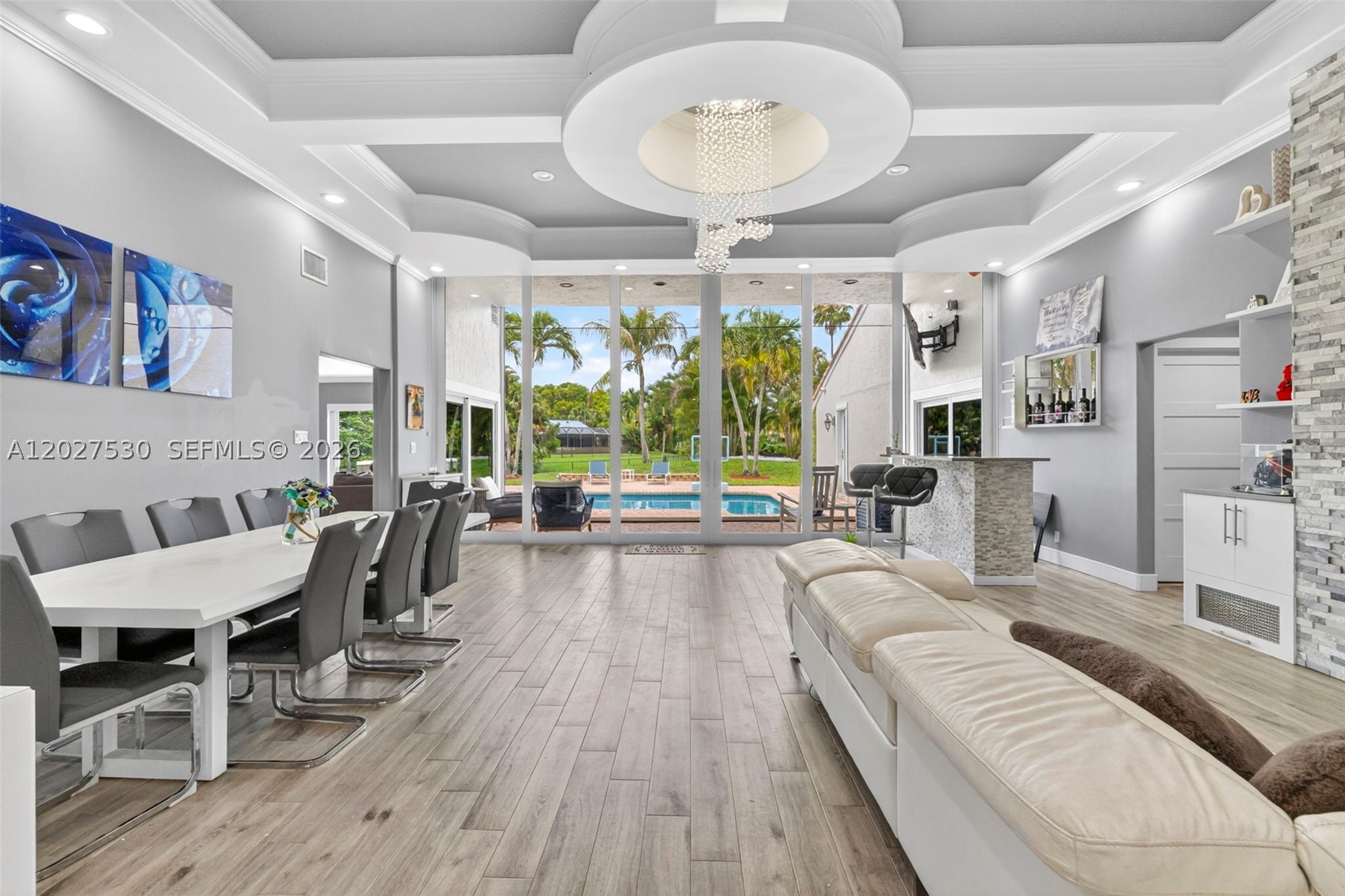 Welcome to this exceptional custom retreat in the highly sought after Cypress Run community with NO HOA. Situated on a private oversized 13,539 sq. ft. waterfront lot, this beautifully updated 4 bedroom, 2.5 bath residence offers 2,859 sq. ft. of luxurious living space and can easily be converted to a 5 bedroom home. Soaring ceilings and dramatic 12 ft floor-to-ceiling custom impact sliders, impact windows and doors flood the home with natural light while showcasing tranquil water views and seamless indoor-outdoor living. Custom finishes throughout include a stunning fireplace feature wall, motorized blinds, illuminated bar, wood-look tile flooring and architectural ceiling. The remodeled kitchen features a large eat-in island, modern cabinetry and updated LG appliances. The private primary suite offers an attached on-suite office room, custom walk-in closets and a spa-inspired bath complete with a microbubble therapy tub, dual shower heads, massage features, handheld sprayers and custom etched glass. Step outside to your private resort style backyard featuring a heated saltwater pool, outdoor jacuzzi, summer kitchen and retractable electric patio screen. Additional highlights include a circular paver driveway, garage conversion with storage, new A/C units and tankless water heater with LED lighting throughout and numerous custom upgrades. A rare opportunity to own a truly one of a kind luxury home offering privacy, style and exceptional indoor-outdoor living!