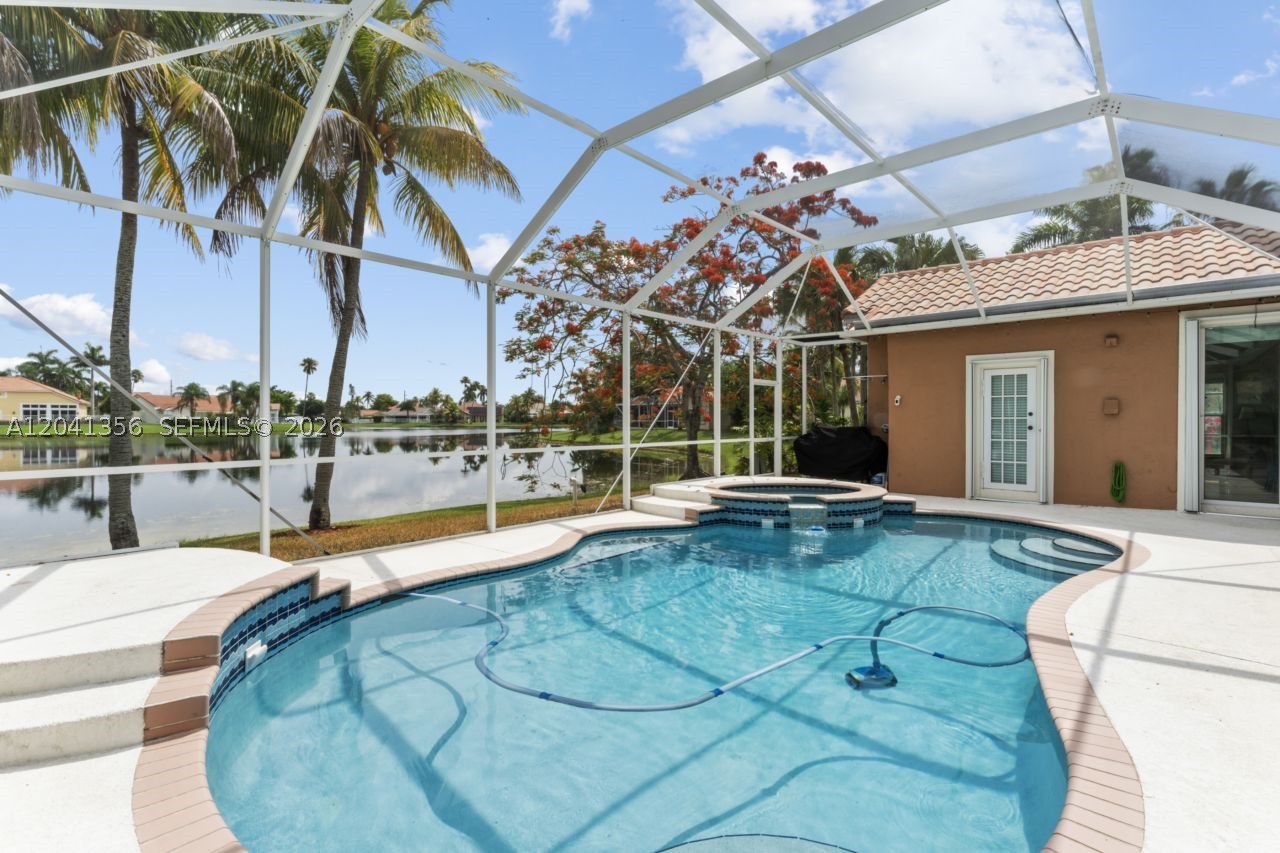 Stunning lake-view home in the highly sought-after, gated community of Laguna Springs I. This oversized corner lot features 4 bedrooms, 3 baths, plus a den perfect for a home office. Enjoy the serene lake view from the renewed screened patio and pool. The kitchen is equipped with stainless steel appliances and granite countertops. Accordion shutters throughout. Additional upgrades include new flooring, 2 renovated bathrooms and a new AC unit. Master suite conveniently located on the first floor with a luxurious master bath featuring a jacuzzi tub. No neighbors to the west side provide added privacy. Available starting Aug 1st. The community pool, clubhouse, and gated entrance are easily accessible. Located in an A+ school district. Lawn, HOA, pool, pest maintenance included. A must-see!