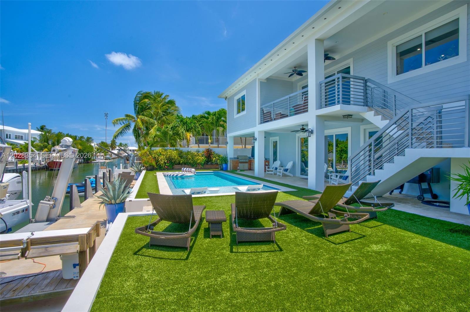 TURN KEY Canal-Front Islamorada Home with Pool, Dock & Private Beach Access Luxury canal-front home in Islamorada offering spacious living, refined coastal design, and exceptional outdoor amenities. This meticulously maintained residence features a flexible split floor plan with a main-level living area, wet bar, bedroom, and full bath overlooking the outdoor kitchen and resort-style pool. Upstairs includes 3 additional bedrooms, 2.5 baths, an open living area, pristine kitchen, and walk-in laundry room/office. The fenced backyard is designed for easy living with turf, low-maintenance landscaping, and privacy! Concrete dock with 20,000 lb boat lift and space for multiple boats. Owners also enjoy access to the private White Marlin homeowners beach and close proximity to area amenities. The perfect Florida Keys getaway with strong monthly rental income potential! A rare opportunity for turnkey waterfront living in the heart of Islamorada.