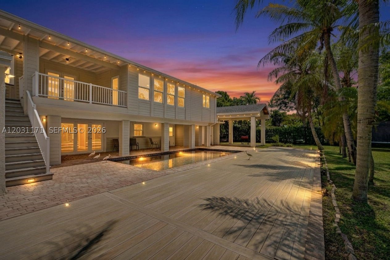 Welcome to this stunning, turnkey Palmetto Bay luxury oasis, completely renovated with over $300K in high-end upgrades. Boasting 3,918 adjusted sq ft of flexible space on an expansive 16,800 sq ft lot, this home greets you with an inviting front living room that flows into a grand family room with soaring vaulted ceilings and exposed beams, flooding the space with light. Versatile layout includes 4 bedrooms upstairs, featuring a massive extra room perfect for a game room or office, with a private door to a balcony and a private staircase leading directly to the backyard. With an additional bedroom downstairs and separate private entrances for both levels, this floor plan offers perfect independent living setups or rental potential. A chef’s kitchen awaits with a walk-in pantry, premium KitchenAid appliances, a new refrigerator, and a custom coffee/wine station. Escape to the primary sanctuary with a large walk-in closet, private terrace access, and a spa bath with a soaking tub. Ideal for toy owners, the exterior boasts a 450 sqft hurricane-resistant boat/RV port, a 2-car garage with an air pump, and an oversized driveway. The resort backyard is a tropical paradise with a 6-foot deep tiled pool and covered porches and wood deck area. Structural updates include a newer roof, new impact windows, newer A/C, natural gas, and a tankless water heater. Near trails, the bay, Coral Reef Park, top-rated schools, and houses of worship. Best deal in the neighborhood—check the comps!