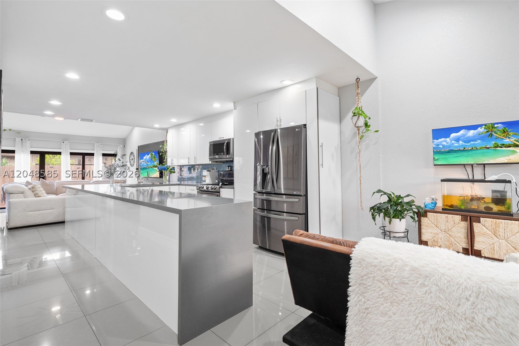 Beautifully remodeled and move-in ready, this gorgeous townhome is nestled in the desirable Arrowhead Golf and Tennis Club community of Davie. Featuring a newer roof and newer A/C, this home has a refinished super high vaulted ceiling in the main living space (no problematic skylights). The chef's kitchen is a true showstopper, boasting a modern minimalist feel with light gray quartz countertops, a double oven, and an abundance of counter and cabinet space—perfect for entertaining. The split bedroom layout includes a full bedroom and full bathroom downstairs, ideal for guests or multigenerational living, plus an oversized primary suite upstairs (not a loft) for privacy. The third bedroom is currently configured as a dining room and can be easily re-configured if needed. A large laundry room provides extra storage and workspace.  Step outside to enjoy the fenced front porch sitting area, perfect for private relaxation, as well as the fenced back patio complete with a storage shed that stays with the home. Residents enjoy  community amenities including a pool, tennis courts, and a playground. Ideally located near major expressways, shopping, Publix, Whole Foods, and Costco, plus close to Broward College, Nova Southeastern University, and area hospitals. This friendly, all-ages community welcomes pets too—don't miss this incredible opportunity!