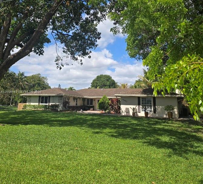 Coming Soon listing! Seller is preparing the home for showings. Interior photos coming in 2 weeks. This elegant four-bedroom, three-bath home sits on over an acre and offers comfort and style. The spacious family room has huge picture windows overlooking a large private fenced backyard with a freeform pool, two pergolas, outdoor speakers, misters, and an 800-square-foot covered patio—ideal for entertaining. Relax in the jacuzzi under the stars or enjoy the butterfly garden at the entryway. The modern 2 tone, white & gray kitchen (40K) features shaker cabinets, quartz countertops and premium appliances. Inside, there are 4 bedrooms, 2 are ensuites, nicely updated/remodeled baths all with glass shower doors. Dual air conditioning units, porcelain flooring throughout, a fireplace, French doors, and fiber optic internet. The laundry room has new washer/dryer and a laundry tub, and provides access to the air-conditioned, tiled garage with impact door. (506 SF, SWEET!)  Special upgrades include a whole-house water filtration system, new pool equipment, a new 30X12 paneled, insulated shed with AC and dehumidifier, an adjacent carport and an extra  180 sf building with air conditioning and French doors that serves as an office or studio, while the 10-year-new roof and impact windows offer peace of mind. 300 ft long double wide driveway can fit all of your toys! Located in an equestrian neighborhood with A-rated schools, this property is ready for you and your horses!