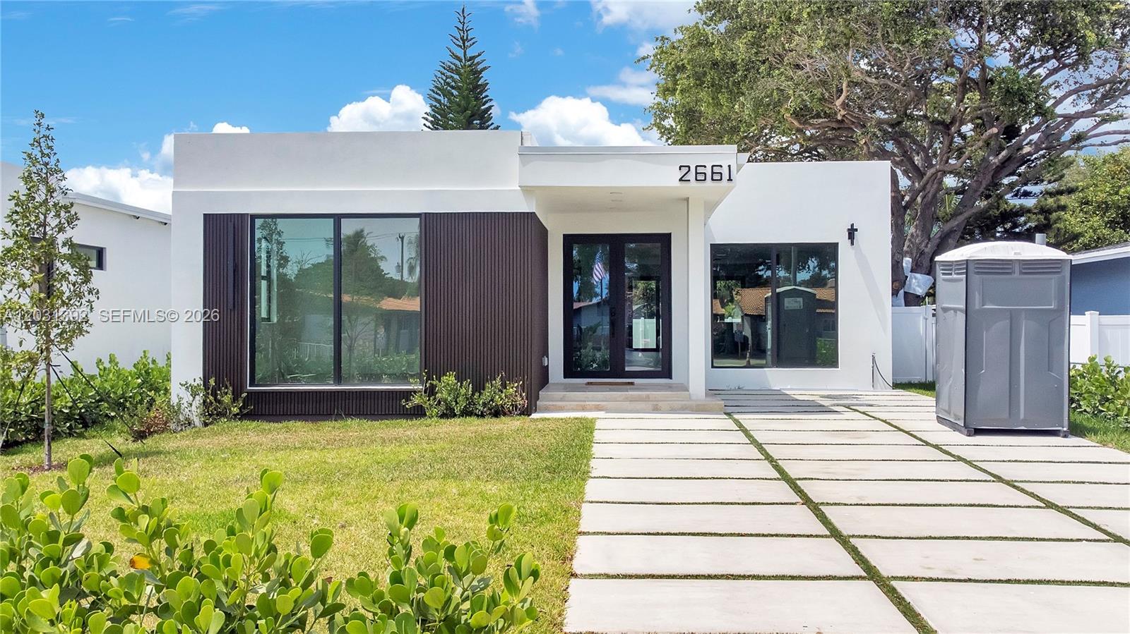 Exceptional new construction designer pool home on Johnson St! Thoughtfully designed 4-bed, 3-bath residence blends modern luxury, quality craftsmanship, and premium finishes on a spacious 7,095 sq ft lot with 2,141 sq ft of living space. Soaring 9-foot ceilings and an open, bright layout create an inviting atmosphere throughout. Built with concrete block construction, this home offers lasting durability and enhanced security.  Beautifully designed custom kitchen is the heart of the home with abundant cabinetry, Samsung appliances, and a wine cooler—perfect for entertaining. Elegant rectified Spanish porcelain flooring flows throughout, adding sophistication and timeless appeal.  Designed for both comfort and efficiency, the home includes impact windows that maximize natural light while helping reduce heat transfer and energy costs. A state-of-the-art A/C system with a 10-year warranty ensures year-round comfort, while LED lighting, modern electrical systems, and integrated fire safety features provide added peace of mind. Designer bathrooms showcase sleek modern fixtures, high-quality plumbing, and stylish tempered glass shower enclosures with elegant finishes. Outside, enjoy a beautifully landscaped setting complete with a stunning pool and travertine deck. The property also features an automated irrigation system with rain sensors and a private well for cost-effective maintenance. Adding even more value, the home is built to the latest FEMA elevation standards!
