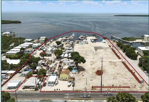 Seize this rare opportunity to develop one of the largest entitled waterfront parcels in the Florida Keys! This 7.4-acre assemblage offers 10 Total parcels, 54(57) ROGO exemptions, 15 transient rights, 30 wet slips, and commercial SF. Multiple parcels sold as a package. Located oceanside at MM 97.5 with excellent visibility and access to boating and tourism. With flexible zoning across multiple land use districts (MU, SC, UR, URM), the site supports a wide variety of uses, including residential, vacation rentals, hospitality, RV park, marina development, or boat storage.  Whether you envision a boutique resort, waterfront rental community, or luxury mixed-use enclave, this is a truly one-of-a-kind investment opportunity in Monroe County.