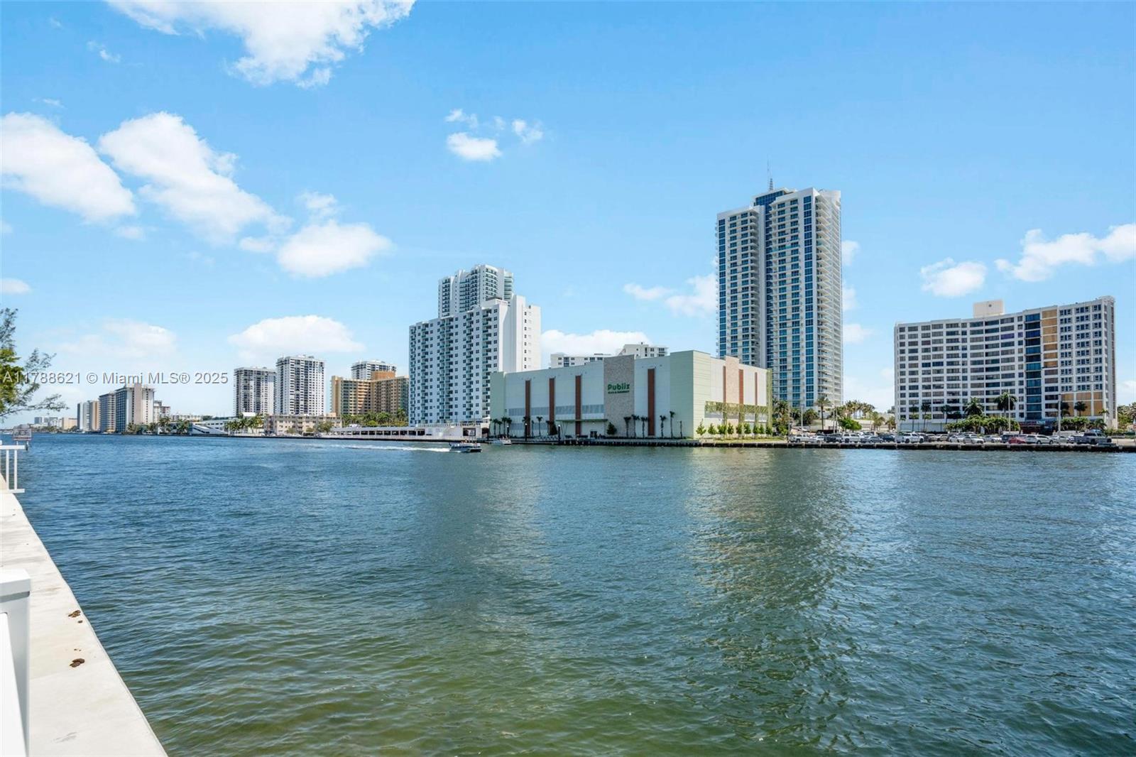 Enjoy intracoastal views from this very cozy residence! Move-in ready, AS IS turnkey unit! Floor-to-ceiling windows, private balcony, verticals throughout, wooden floor.  Master suite plus den (convertible) 2nd bathroom. Building has 24 hours concierge and security. Social room and gym room. Three Islands lifestyle, waterfront clubhouse, pool, BBQ/picnic area, tennis courts. Conveniently located, minutes to beaches, to variety of shopping and dining, and Gulfstream Park. One assigned opened parking #228. One storage #017. Wi-Fi included in HOA as of 8/01/2025. Seller may remove only a few personal belongings. New AC unit installed in Sep.2025
