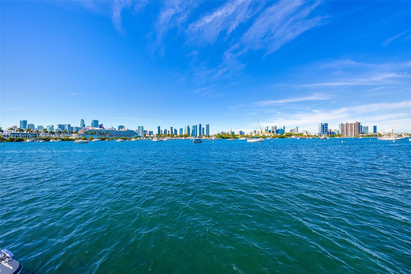 Experience the chance to build your dream home or update the current 2-story waterfront residence on Palm Island’s sought-after western tip, showcasing panoramic views of the Miami skyline and Biscayne Bay. The home features travertine and original wood floors, a spacious family room, and an open living area with direct access to the pool deck. The open kitchen offers a center island and an adjacent dining area. The 2nd-floor primary suite includes custom closets and a lounge area overlooking the city and bay. Outdoors, enjoy a heated pool, seating areas, and covered porch. Boaters will appreciate 78’ of waterfront, private dock, and easy ocean access.