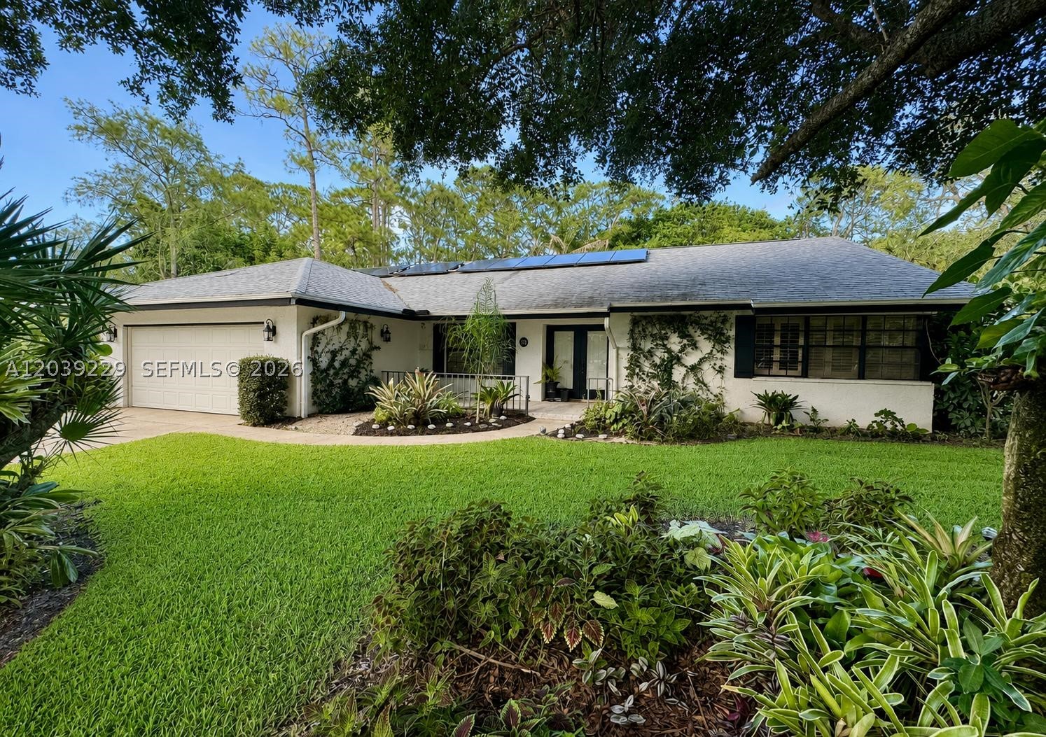 Tucked right in the vibrant heart of Wellington,4/2/2 (den conversion) + office turnkey masterpiece is architecturally designed by a high-end professional team for an immediate 'wow' factor. Sitting on a fenced 0.5 acre lot with a breathtaking, serene botanical garden sanctuary, the home features a 2022 roof, spacious 4BR/2BA split plan (4th bedroom is Den conversion).  The interior features imported Spanish porcelain flooring throughout for a smooth, welcoming feel. Formal Dining room. The chef’s kitchen boasts quartzite Taj Mahal countertops, custom walnut cabinetry, and premium Café appliances with an induction island cooktop and a separate built-in Advantium® 5-in-1 wall oven(WiFi). Nearby, a utility room offers an LG W/D with matching custom walnut cabinets. A large home office faces the spectacular gas-heated pool with Spa (new pump), solar hot/cold outdoor shower, screened patio with hurricane protection. A/C 2019 & ceiling fans keep the interior perfectly cool. A custom impact skylight, Plantation shutters, a hurricane garage door, impact windows, shutters & panels offer complete storm peace of mind.  The property operates on a solar system, city water, septic, and full irrigation via a brand-new 2026 well pump. Lush, mature fruit trees complete this secluded oasis. Enjoy total privacy with NO HOA, just minutes to world-class equestrian venues, dining, shopping, and the Turnpike. Top "A"-rated schools in a family oriented town—simply turn the key and live your dream.