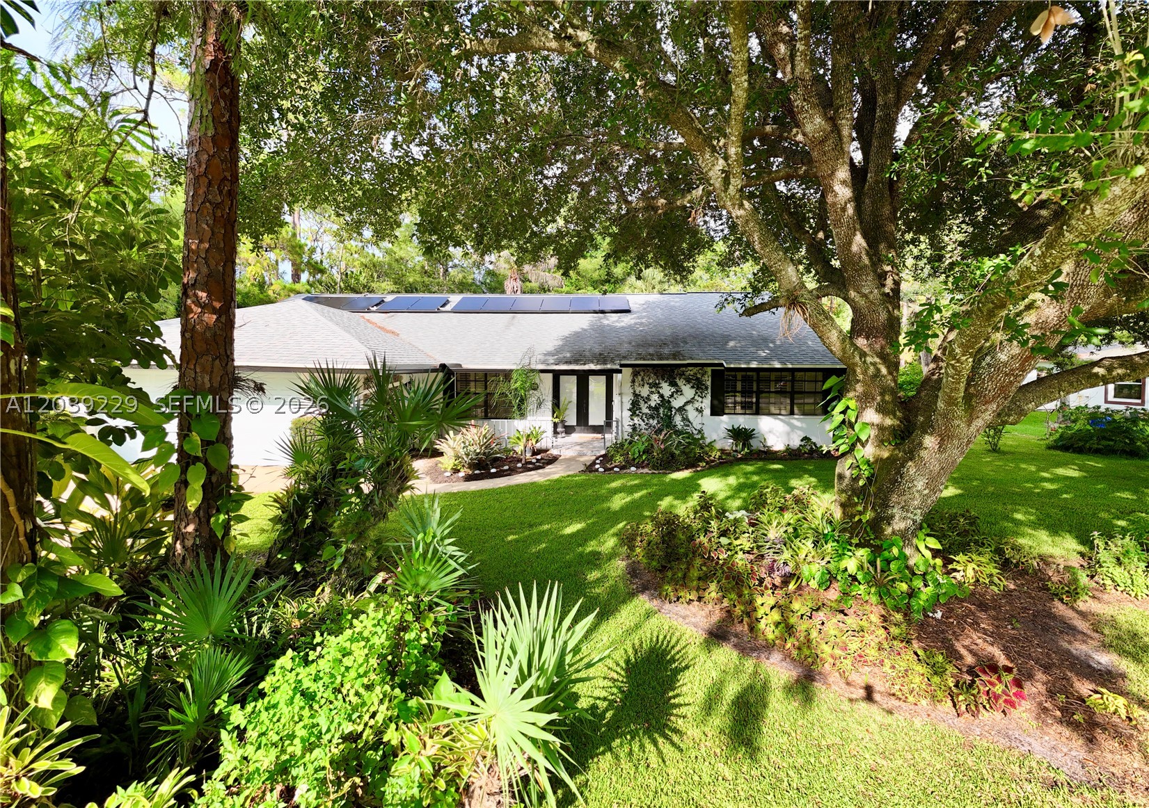 Tucked right in the vibrant heart of Wellington,4/2/2 (den conversion) + office turnkey masterpiece is architecturally designed by a high-end professional team for an immediate 'wow' factor. Sitting on a fenced 0.5 acre lot with a breathtaking, serene botanical garden sanctuary, the home features a 2022 roof, spacious 4BR/2BA split plan (4th bedroom is Den conversion).  The interior features imported Spanish porcelain flooring throughout for a smooth, welcoming feel. Formal Dining room. The chef’s kitchen boasts quartzite Taj Mahal countertops, custom walnut cabinetry, and premium Café appliances with an induction island cooktop and a separate built-in Advantium® 5-in-1 wall oven(WiFi). Nearby, a utility room offers an LG W/D with matching custom walnut cabinets. A large home office faces the spectacular gas-heated pool with Spa (new pump), solar hot/cold outdoor shower, screened patio with hurricane protection. A/C 2019 & ceiling fans keep the interior perfectly cool. A custom impact skylight, Plantation shutters, a hurricane garage door, impact windows, shutters & panels offer complete storm peace of mind.  The property operates on a solar system, city water, septic, and full irrigation via a brand-new 2026 well pump. Lush, mature fruit trees complete this secluded oasis. Enjoy total privacy with NO HOA, just minutes to world-class equestrian venues, dining, shopping, and the Turnpike. Top "A"-rated schools in a family oriented town—simply turn the key and live your dream.