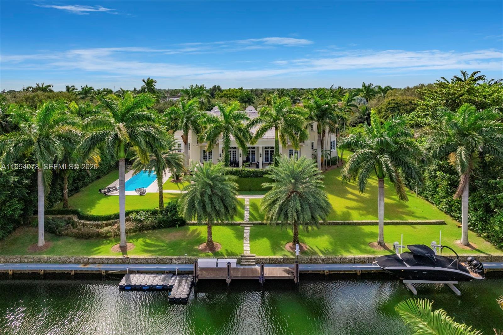 Spectacular waterfront estate in the exclusive, guard-gated community of Gables Estates, offering 9,236 SF under air  and 12,102 total, on beautifully landscaped grounds. With 6 bedrooms, 6 full baths, and 2 half baths, this residence blends timeless Dutch and Island-inspired architecture with refined luxury. Designed with distinct east and west wings, the home features double-height ceilings, an elegant Connemara marble staircase, marble and wood floors, and grand living and formal dining rooms. The chef’s kitchen is equipped with Gaggenau appliances, Sub-Zero refrigeration, custom cabinetry, and a spacious island with seating, opening to a bright breakfast area and family room. Additional highlights include a library with custom millwork, two fireplaces, elevator, and advanced home systems. The private main suite offers a serene retreat with terrace access, dual walk-in closets, and a luxurious marble bath featuring a long mirrored vanity, Jacuzzi, and multi-jet shower. Outdoors, enjoy 180 feet of waterfront with a 20,000 lb boat lift and direct, no-bridge access to Biscayne Bay. Covered terraces overlook the pool and manicured gardens, complemented by a 4-car garage and expansive driveway—an exceptional waterfront offering where elegance meets effortless coastal living.
