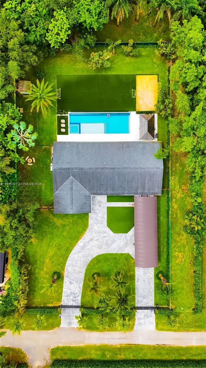 The house features bathrooms and a kitchen that were completely remodeled in 2024. Also added in 2024 was a 50-foot by 18-foot infinity-edge pool, equipped with a heater, a saltwater system, and full automation. The property boasts a synthetic-turf soccer field and a sandy beach volleyball area. The lot spans nearly an acre and is divided by a fence into two sections—each with its own independent entrance—making the undeveloped portion ideal for a business venture or for building a guest house. The driveway features a covered canopy tall enough to shelter a boat or an RV. The home is served by well water and includes a two-car garage. Currently, the property operates as an Airbnb rental; it comes fully furnished and equipped, allowing a new owner to seamlessly continue the business—a process currently managed by a dedicated administrator. The entire operational infrastructure is already in place to ensure the business continues without interruption; we can provide Airbnb financial statements so prospective buyers can review the revenue figures. The roof and air conditioning system were already installed when we purchased the property in 2021, though they were relatively new at the time. This residence offers spacious interior and exterior living areas, featuring beautiful garden spaces with tremendous potential for a wide variety of uses.