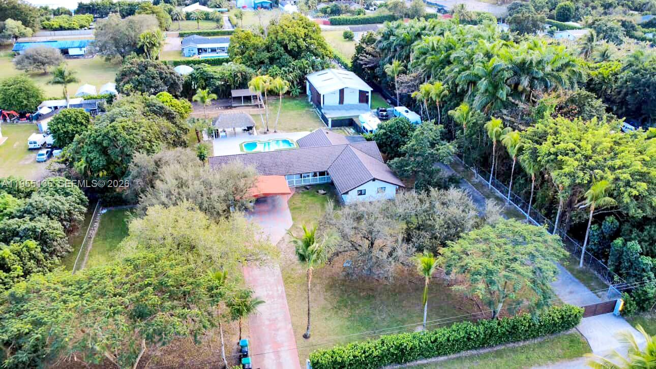 Do you love living in Miami but without the noise of the city? Do you also dream of having your own business or storage space right in your backyard? This unique property is more than a home — it’s a lifestyle where privacy, freedom, and a love for nature come together. Featuring over 5,000 sq ft of living area on nearly 1.5 acres, this exceptional property includes a warehouse, pool, and tiki bar. The main residence is fully remodeled and offers 4 bedrooms and 3 bathrooms, including two spacious primary suites, a brand-new modern kitchen with granite countertops, remodeled bathrooms, and new flooring throughout. At the rear of the property, you’ll find a work area with a fully remodeled 3-bedroom, 2-bath guest with kitchen, perfect for extended family, staff, or business use. The expansive lot features a beautiful pool area with tiki hut, bar, and storage shed, plus ample space for boats, trailers, and RVs.