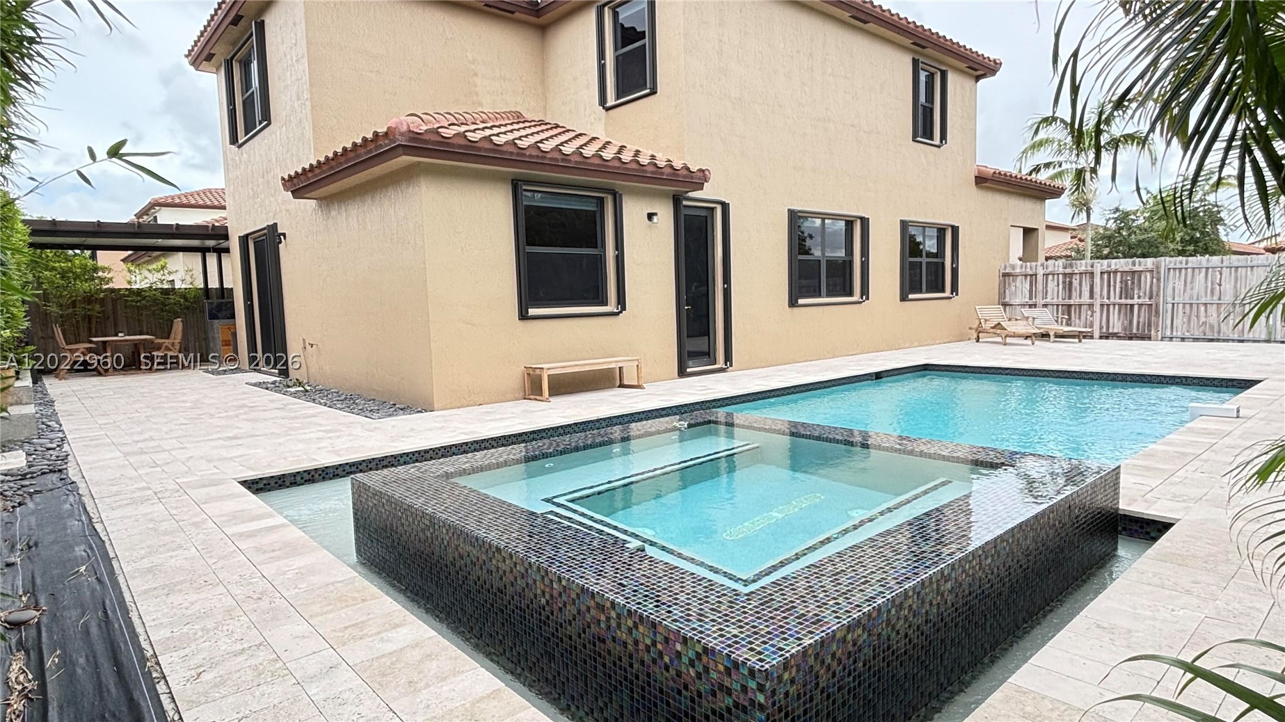 Rare oversized home lot in aisles of Oasis featuring  resort-style backyard built for entertaining. Enjoy a large pool with built-in jacuzzi -  heat exchange system, pool equipment is wifi enabled. Outdoor living includes travertine pool deck, custom outdoor kitchen with Viking cooktop, and free standing Argentinian grill.Lush bamboo, and Areca palm privacy landscaping. Full home water filtration system. Interior features include granite countertops, epoxy marble-style garage flooring, and modern finishes with home automation features throughout. Conveniently located minutes from Publix, shopping, dining, and the Florida Turnpike entrance for easy commuting.