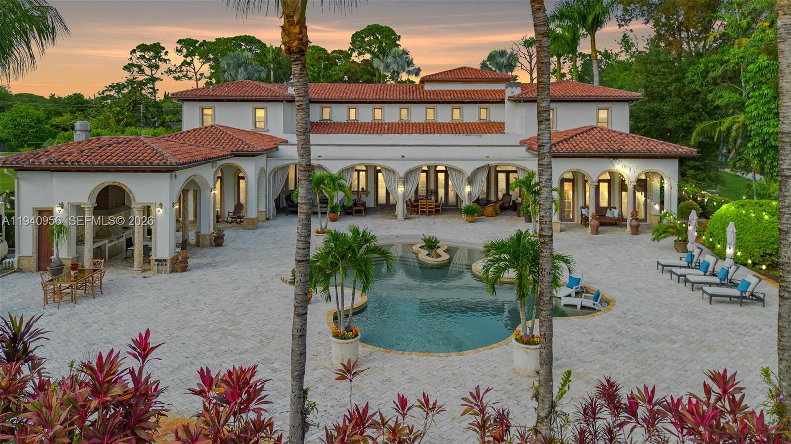 Experience authentic resort-style living in the heart of Miami, ideally located near top schools, dining, and shopping. While the interior impresses with a grand foyer, soaring ceilings, and a handcrafted staircase, the property’s true crown jewel is the spectacular outdoor oasis. Designed for effortless entertaining and relaxation, the backyard features a stunning beach-entrance pool and a fully equipped summer kitchen and barbecue area, all framed by a covered patio that invites the Caribbean breeze. Inside, the home blends classic luxury with modern peace of mind, featuring Venetian plaster, a custom bar with a wine cellar, and essential upgrades including impact windows, a diesel generator, and a 5-ton A/C unit. The layout provides exceptional comfort with a main-floor primary suite and six additional bedrooms upstairs, including a private guest suite and service quarters. Secured by a gated entrance and a four-car garage, this residence offers a private, vacation-like escape every day of the year.