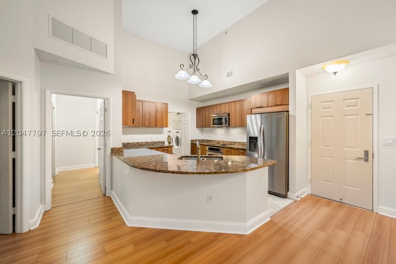 This is the largest apartment available at Veranda and the only first-floor residence of its kind, offering an impressive 1,644 square feet of living space. Featuring soaring 14-foot ceilings and three separate private entrances, this unique home combines spaciousness, convenience, and privacy. The apartment has been beautifully updated with laminate flooring, impact-resistant windows, stainless steel appliances, granite countertops, and a separate laundry room. It has also been freshly painted throughout and is move-in ready for immediate occupancy. Rent includes water, high-speed internet, cable television, and two assigned parking spaces in the secured garage. Residents enjoy Veranda's exceptional resort-style amenities, including a heated swimming pool, fitness center, sauna, library, 24-hour concierge service, and on-site management. Ideally located in the heart of Plantation, Veranda is just steps from supermarkets, restaurants, medical facilities, places of worship, and offers easy access to major highways, shopping, and entertainment. This is a rare opportunity to enjoy one of the community's most distinctive residences.
